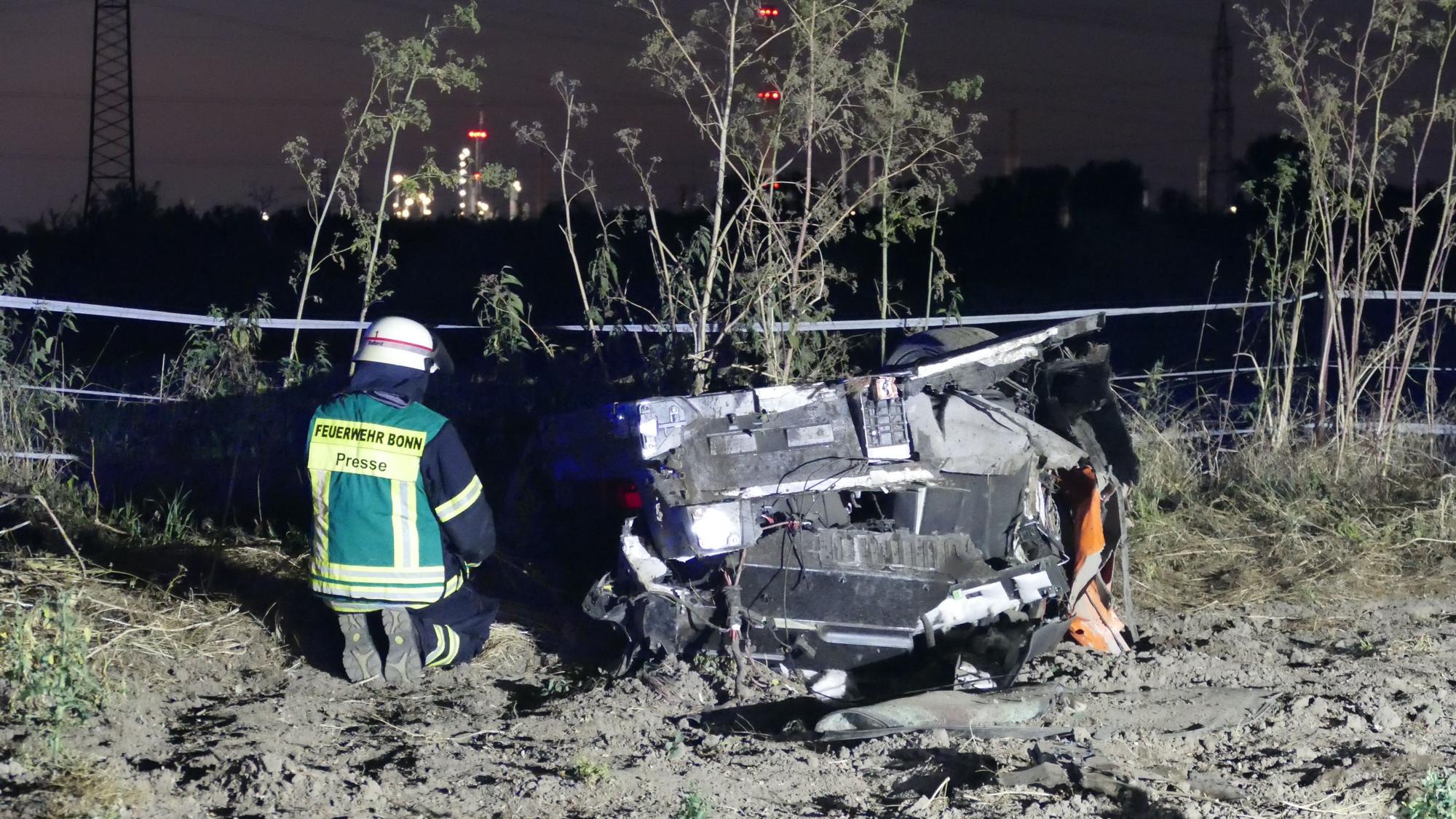 Ein Feuerwehrmann kniet neben dem Autowrack.