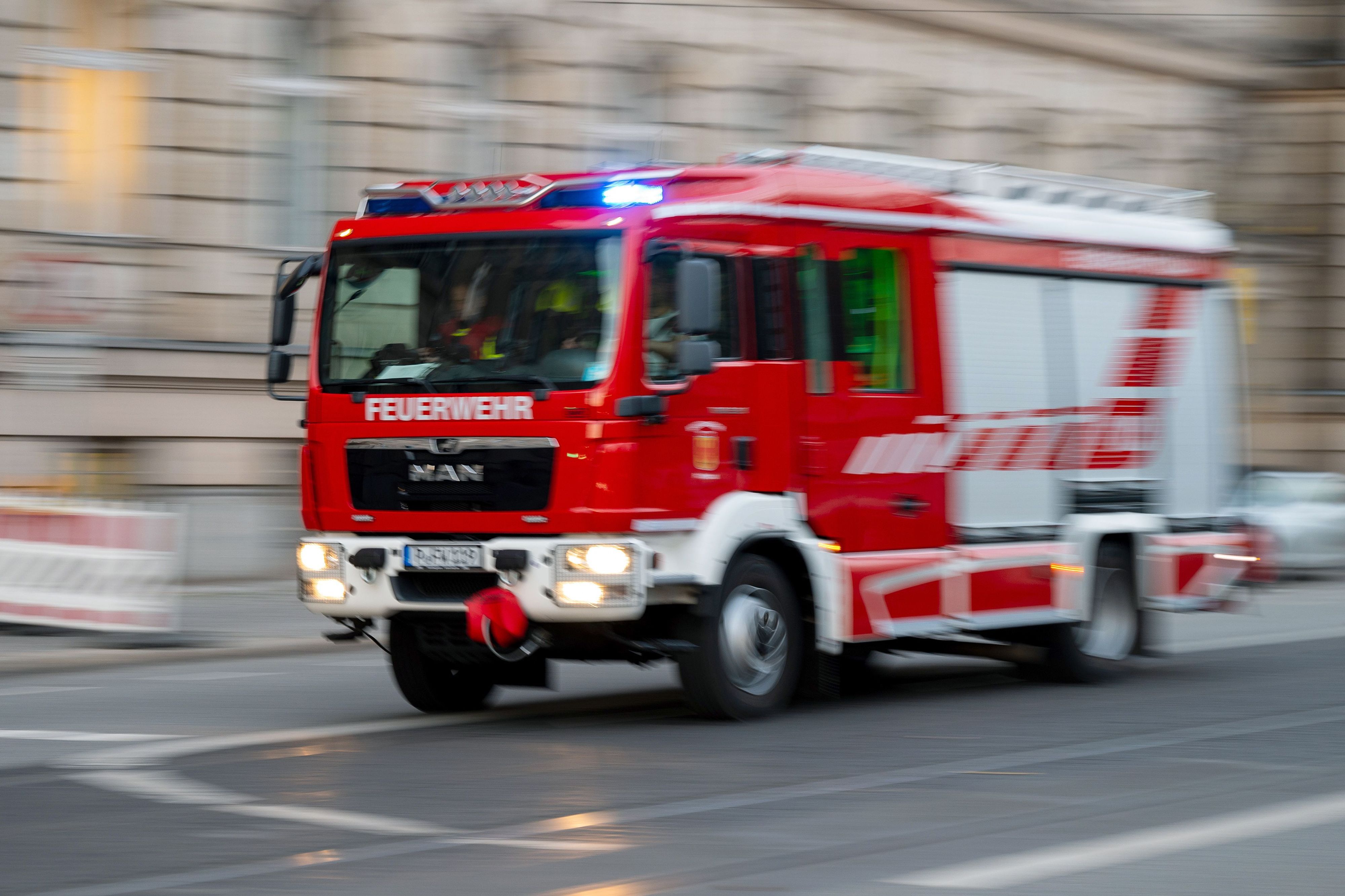 Ein Feuerwehrauto mit eingeschaltetem Blaulicht fährt zum Einsatz.