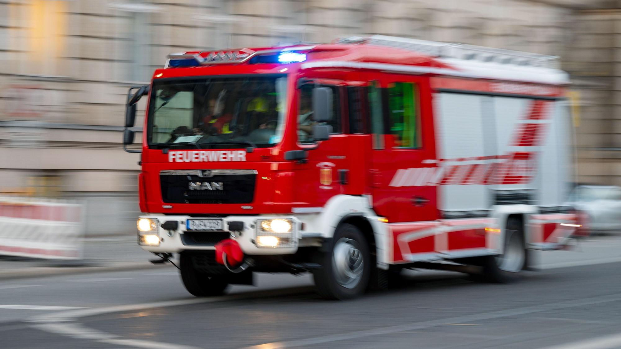 Ein Feuerwehrauto mit eingeschaltetem Blaulicht fährt zum Einsatz.