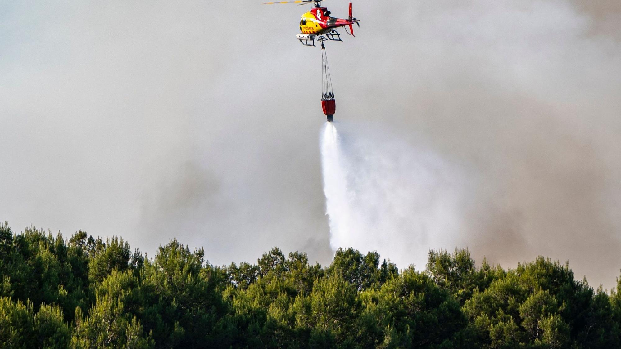 Ein Löschhubschrauber ist im Juli 2026 während eines Waldbrandes in Pla de Manlleu im Einsatz.