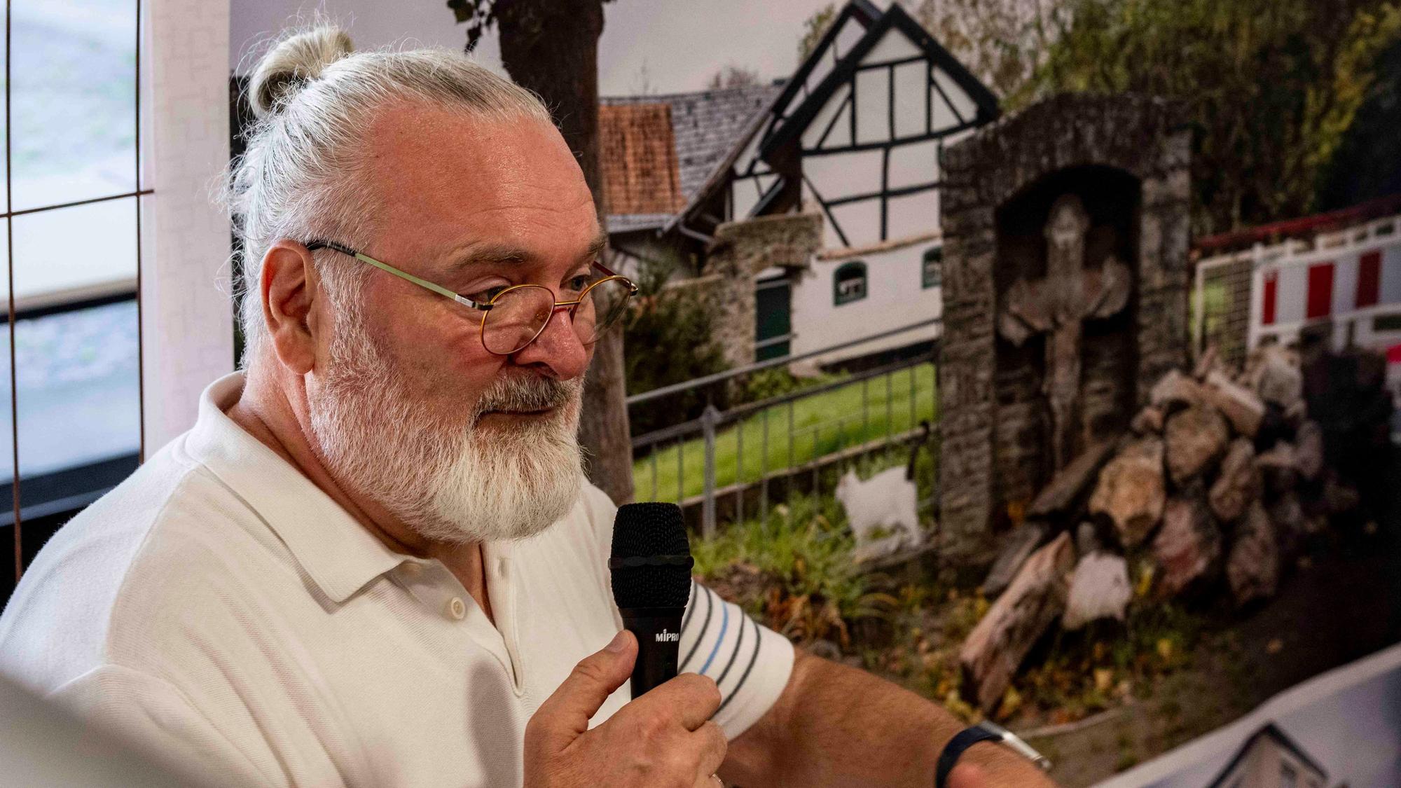 Das Bild zeigt Joachim Rieger mit einem Mikrofon in der Hand.