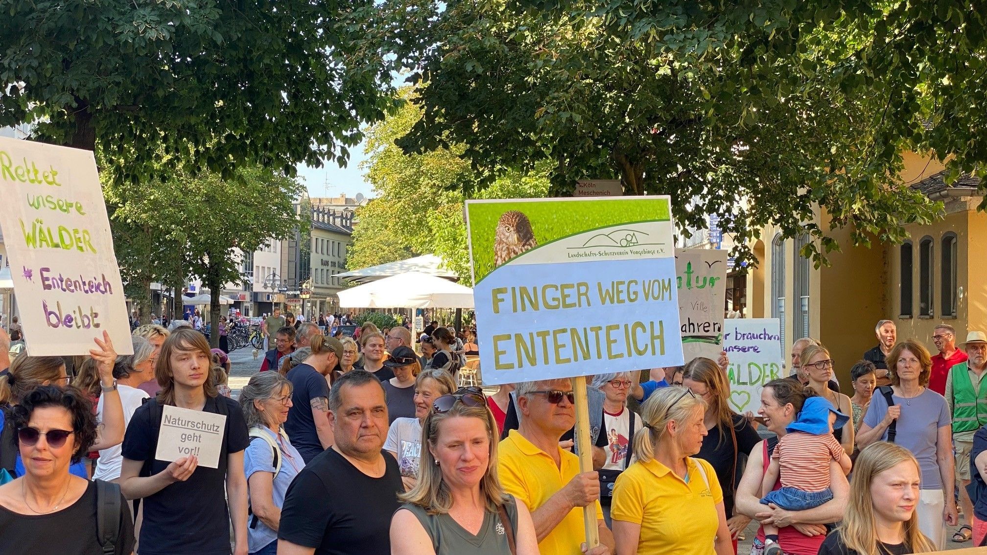 Zu sehen sind Demonstranten, sie halten Schilder hoch.