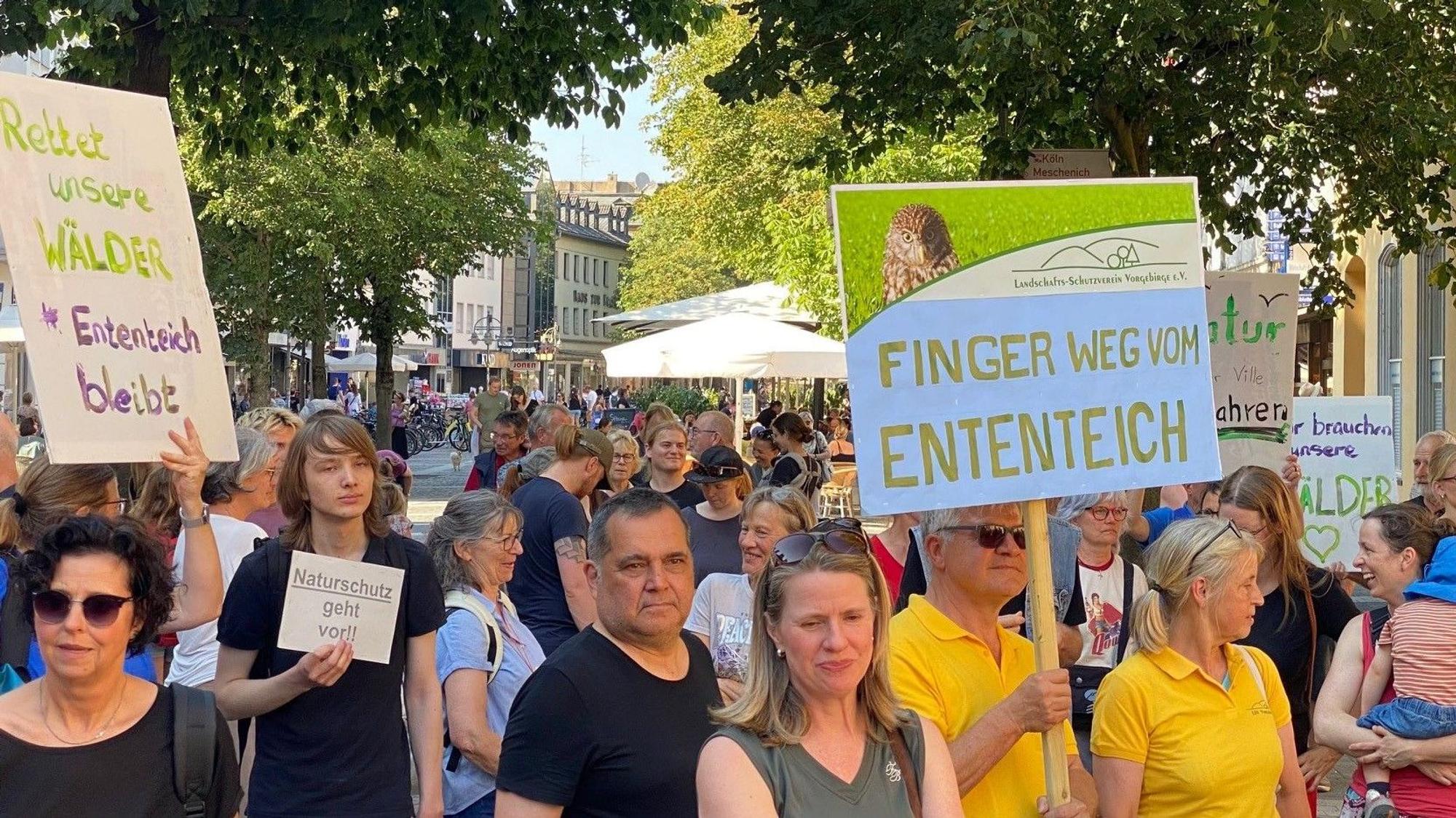 Zu sehen sind Demonstranten, sie halten Schilder hoch.