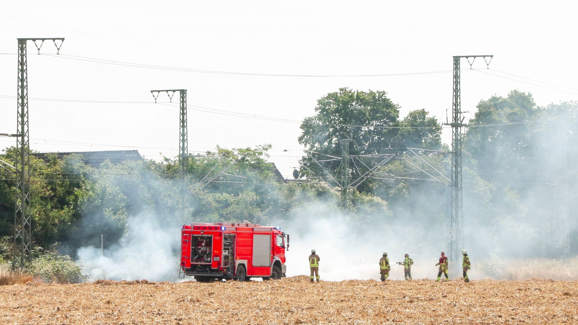 Feuerwehrleute bei Löscharbeiten an der Bahnstrecke bei Langenfeld. Nach einem Böschungsbrand bleibt die wichtige Bahnstrecke zwischen Düsseldorf und Köln bis mindestens Samstagnachmittag gesperrt.