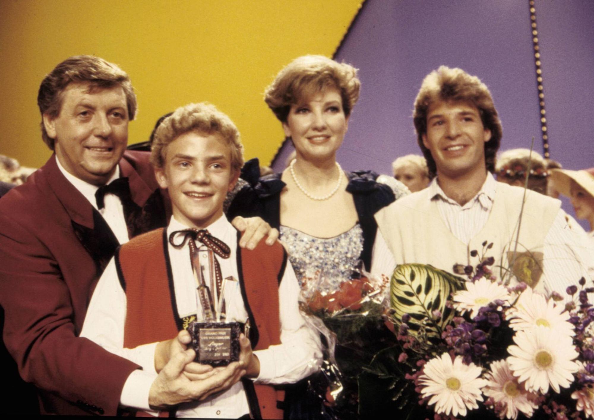Seine Karriere begann mit dem Sieg beim „Grand Prix der Volksmusik“ 1989: Stefan Mross (zweiter von links) feiert mit Karl Moik (links), Carolin Reiber und Patrick Lindner (Bild: IMAGO / Spöttel Picture)