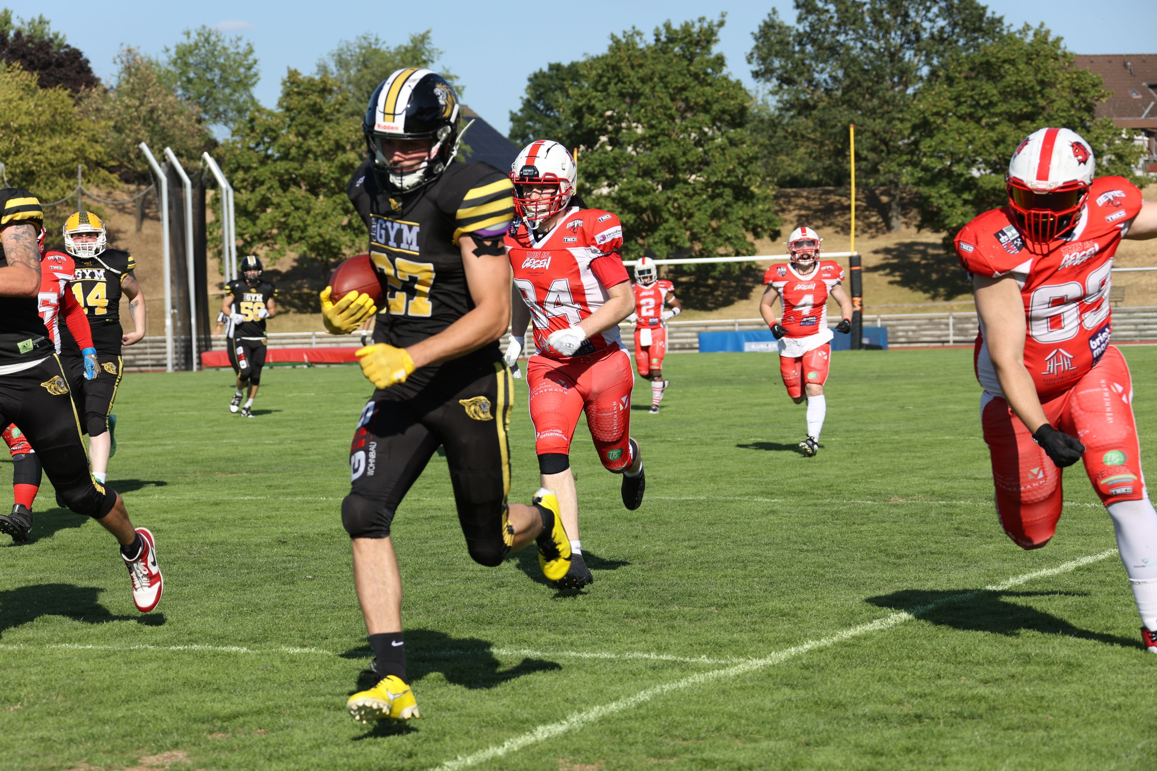 Fynn Handschke läuft, mit dem Football unter dem Arm, den Gegenspielern davon.