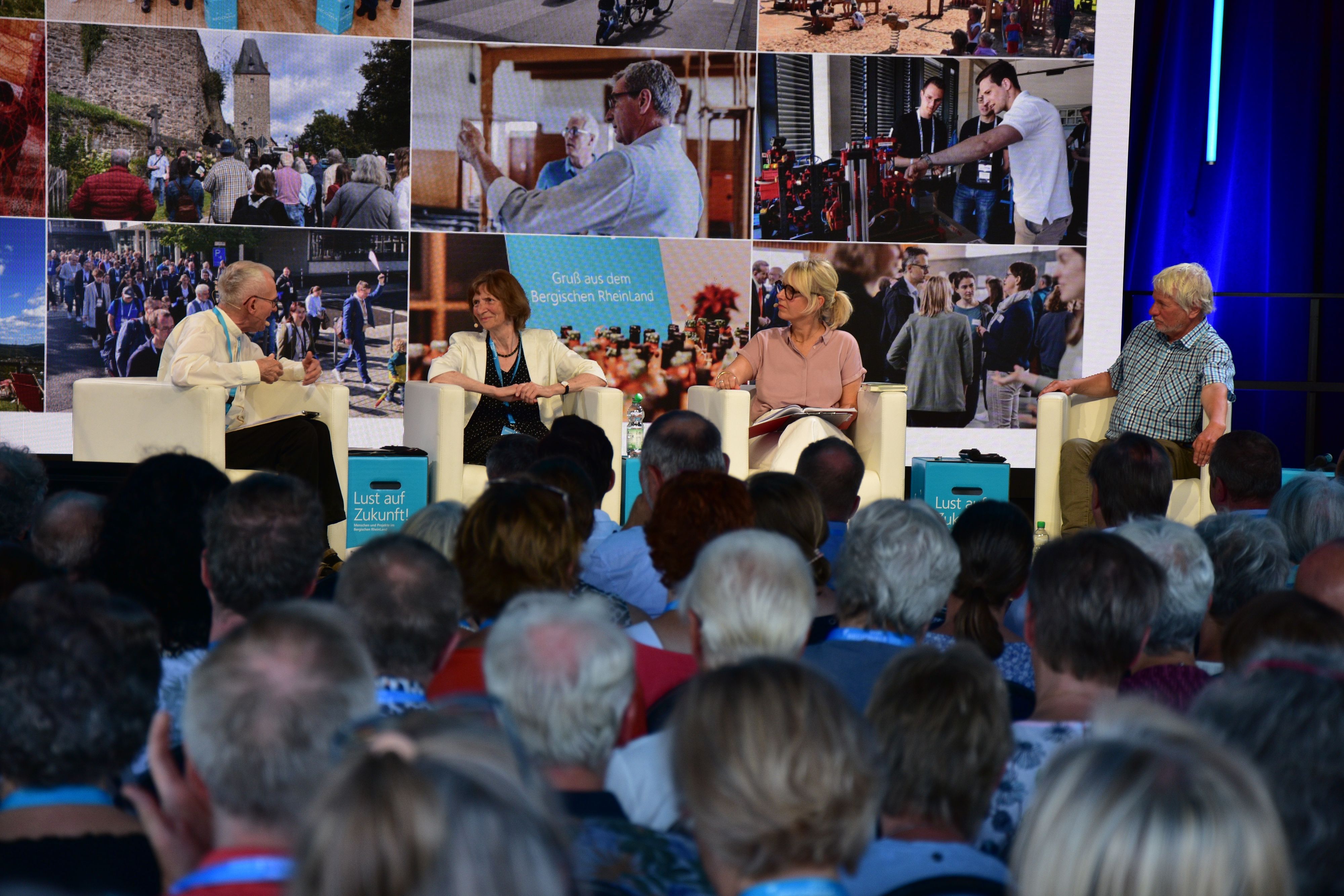Zeltfestival zum Abschluss der Regionale in Much. Franz Meurer, Pfarrer in Köln-Höhenberg und -Vingst, Autorin Aleida Assmann, Moderatorin Julia Schöning und Kabarettist Jürgen Becker.
