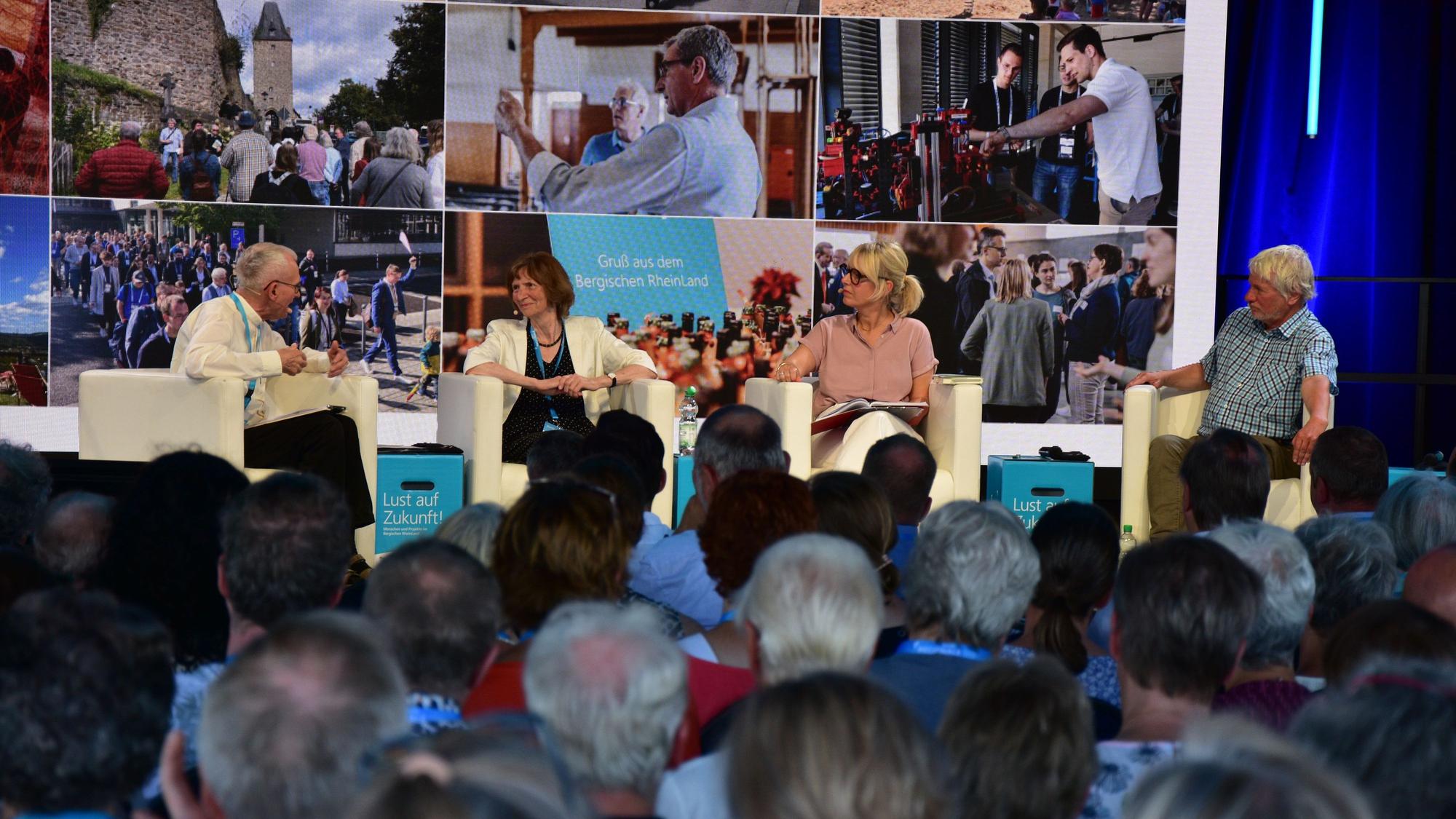 Zeltfestival zum Abschluss der Regionale in Much. Franz Meurer, Pfarrer in Köln-Höhenberg und -Vingst, Autorin Aleida Assmann, Moderatorin Julia Schöning und Kabarettist Jürgen Becker.