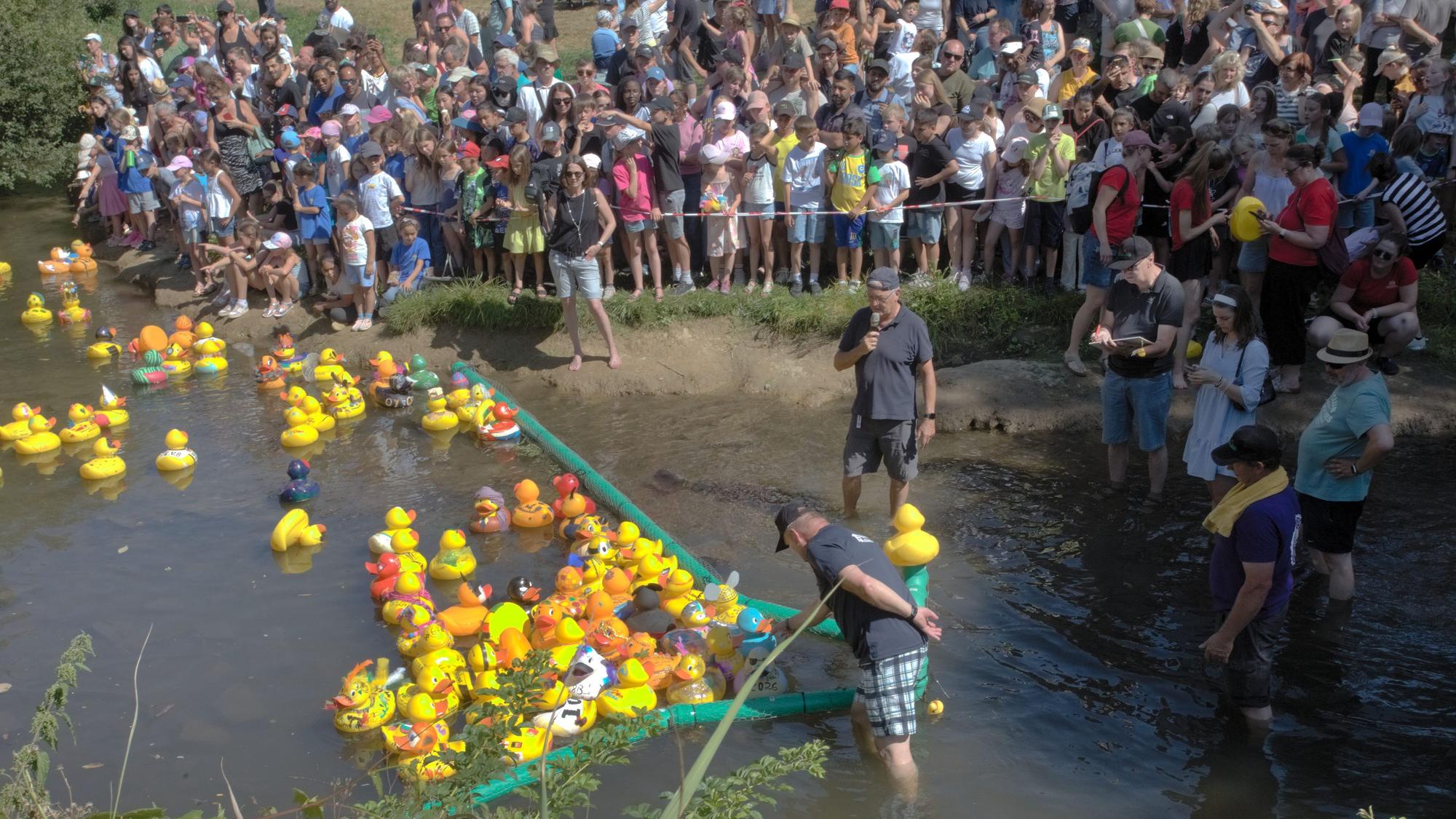 Großes Gedränge auf den Ohler Wiesen entlang der Wupper und ebenso auf dem Wasser: Die 143 Mutterenten erreichen beim Entenrennen in Wipperfürth eher gemächlich das grüne Zieltor.