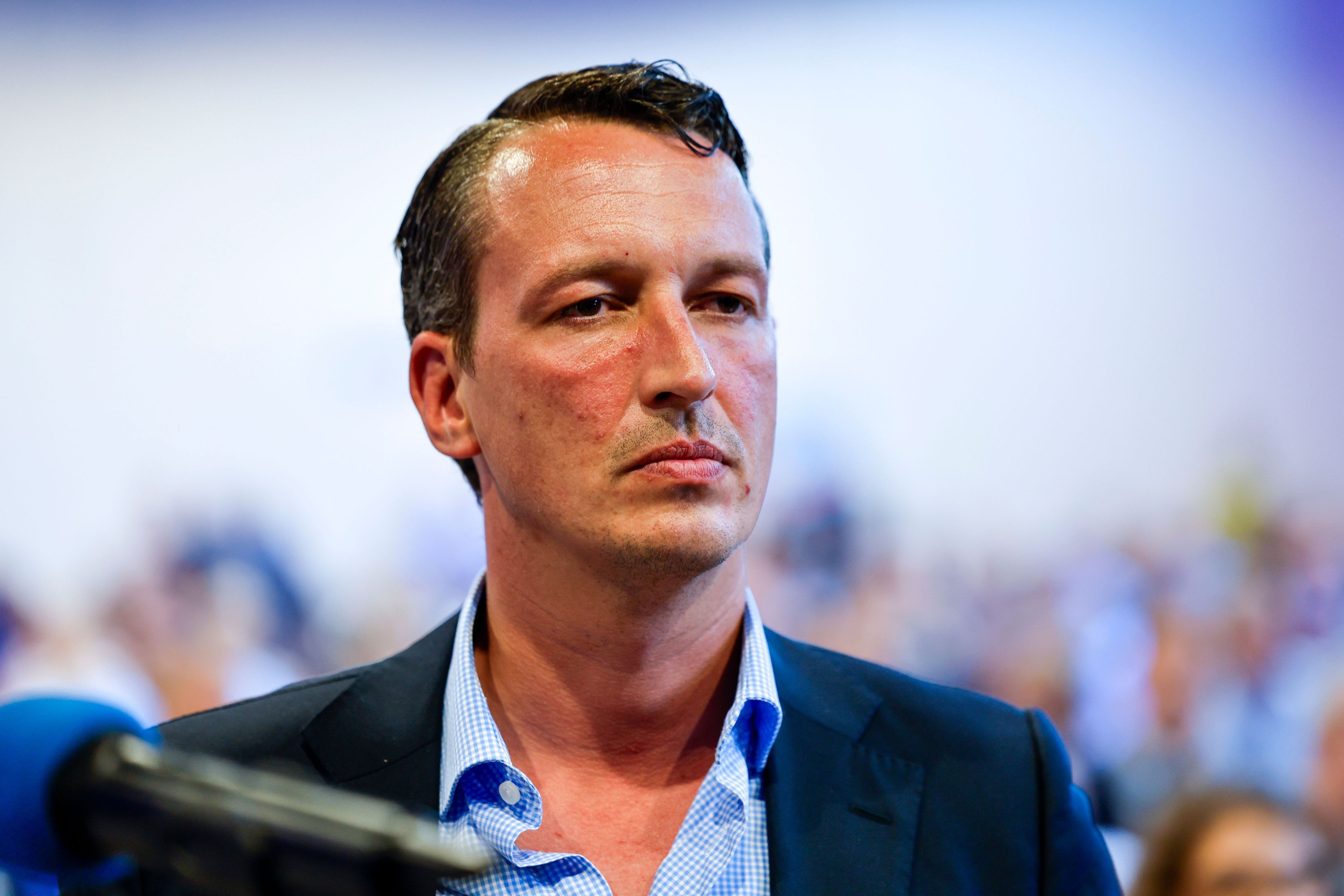 Der Bundestagsabgeordnete Matthias Helferich  (AfD) steht im Versammlungssaal.