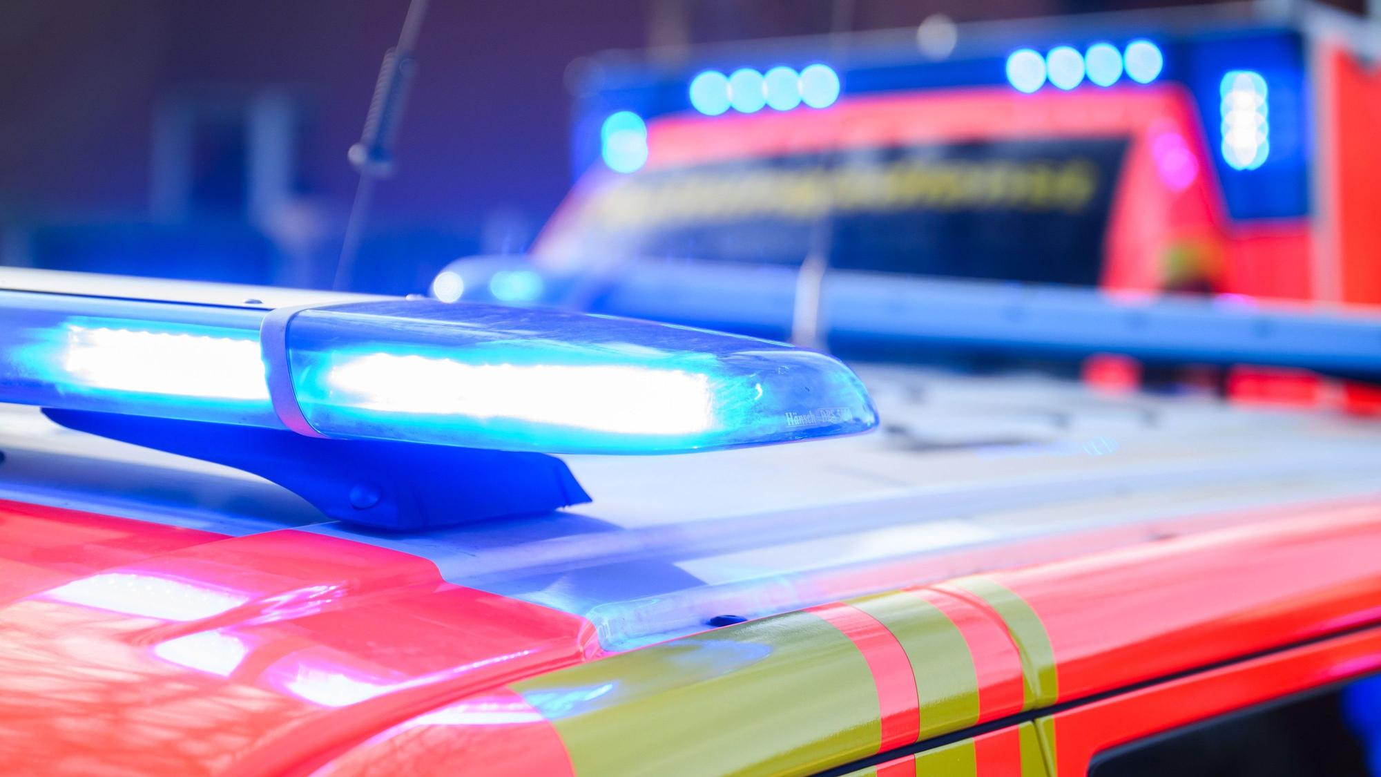 Blaulichter leuchten an einer Einsatzstelle auf einem Notarztfahrzeug und einem Rettungswagen.