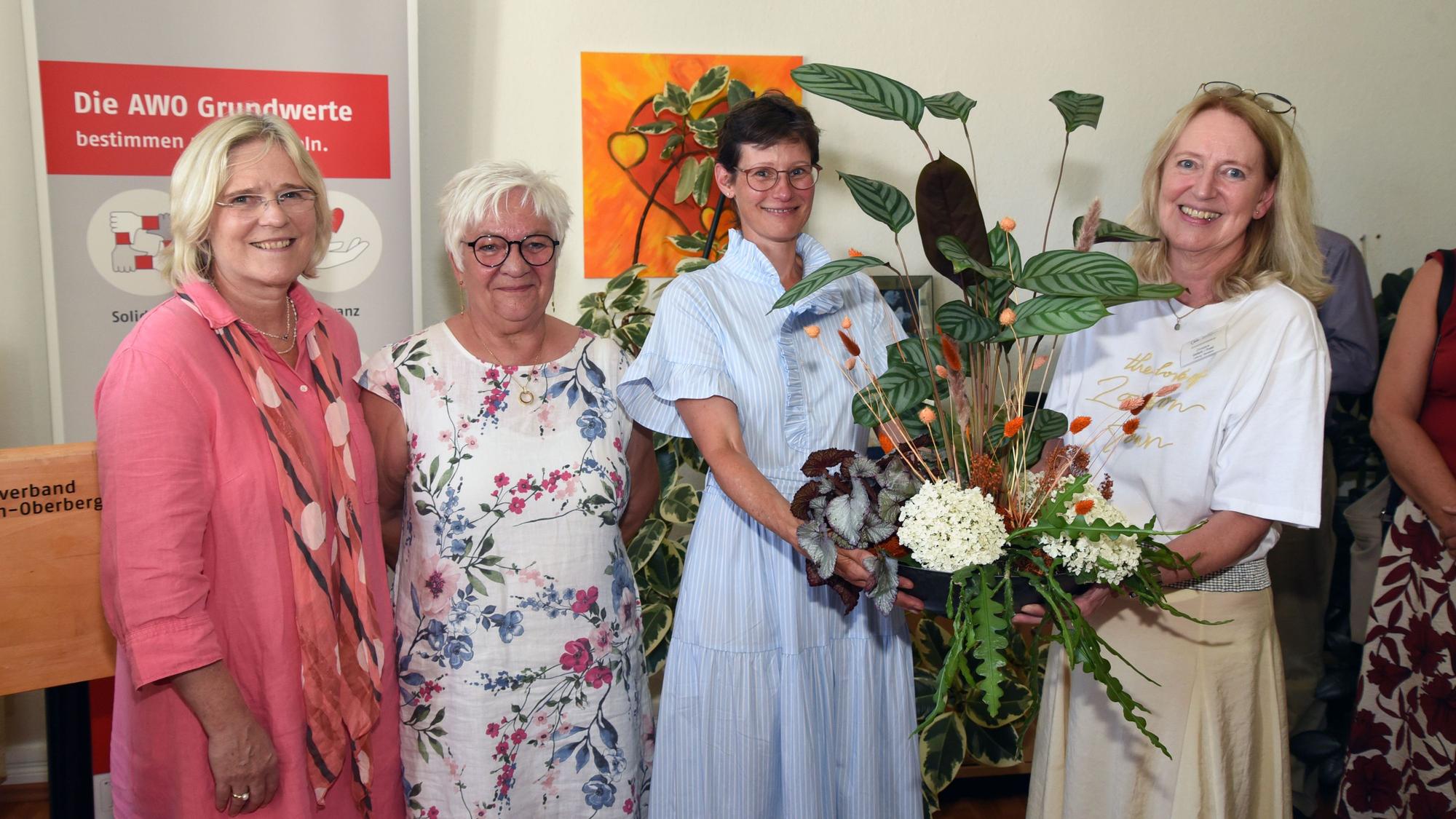 Vier Frauen und ein Blumenstrauß.