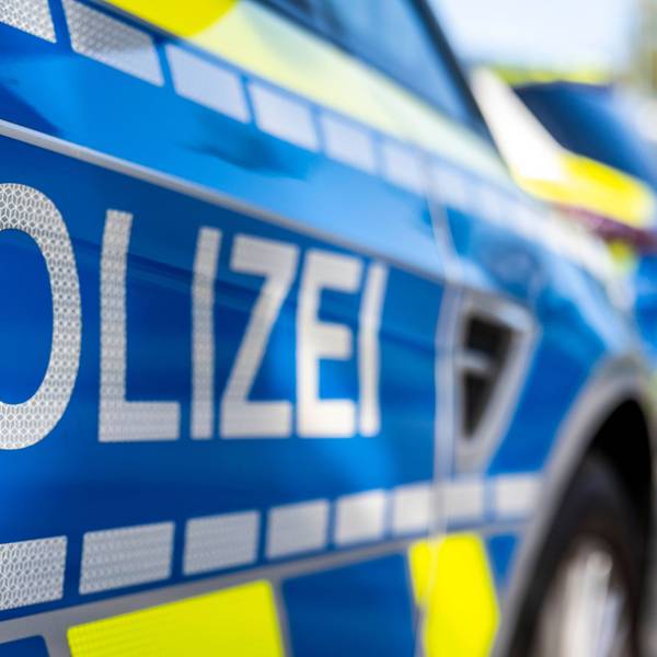 An der Tür eines Streifenwagens steht der Schriftzug „Polizei“.
