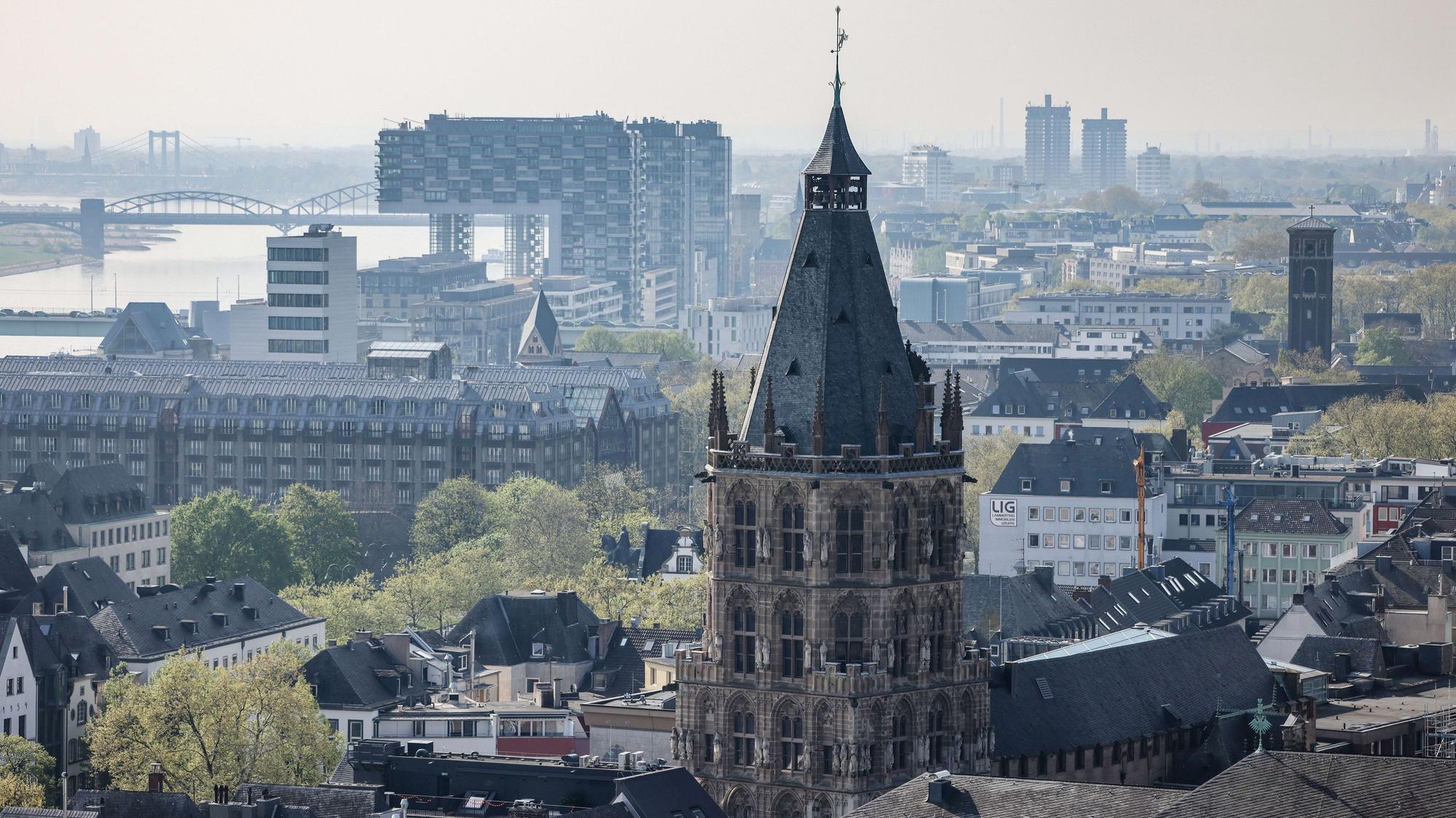 Blick auf den Kölner Rathausturm, im Hintergrund der Rhein und die Kranhäuser