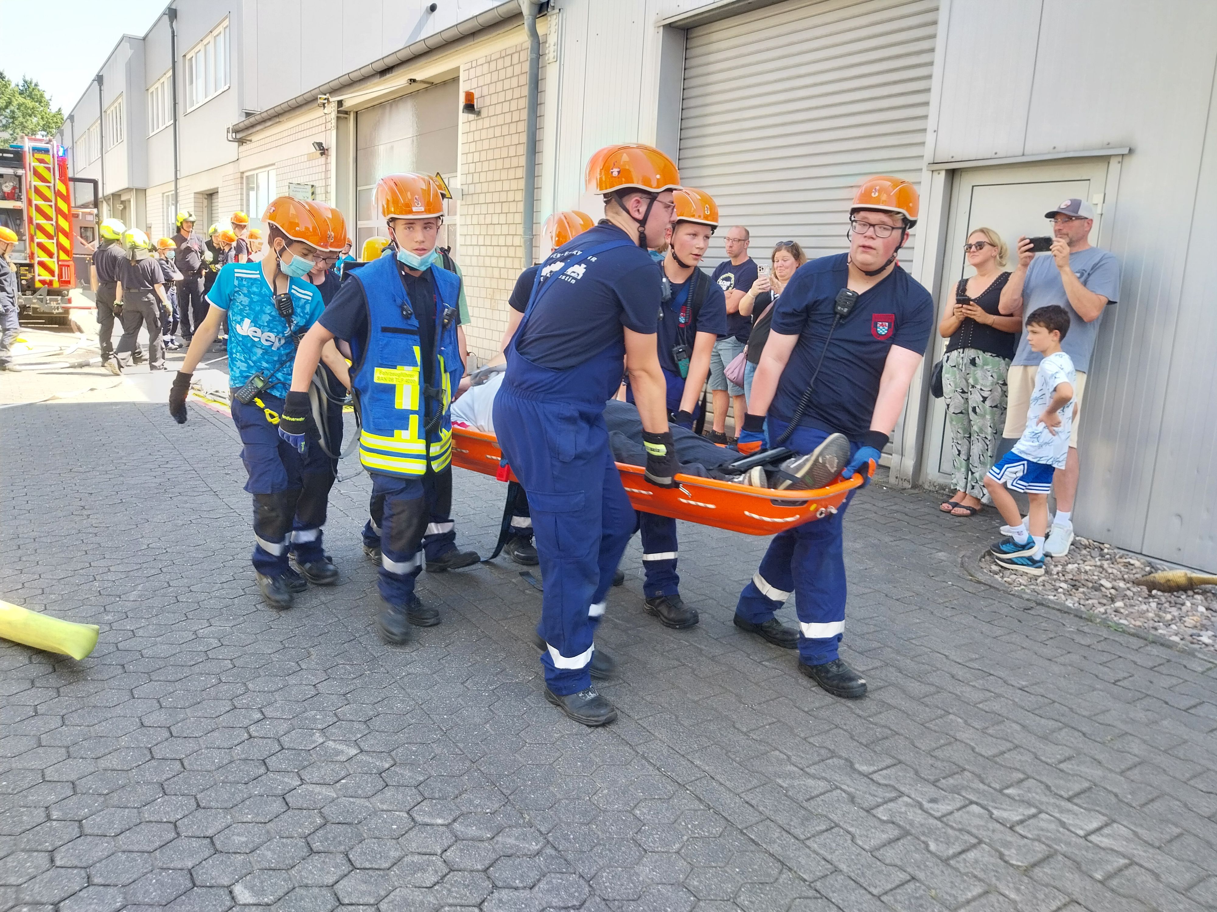 Gemeinsam retten die Kinder und Jugendlichen einen Verletztendarsteller mit der Schleifkorbtrage.