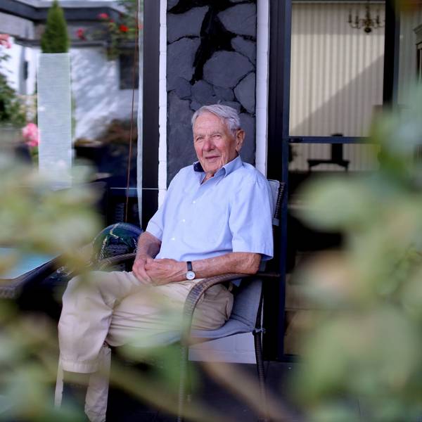 Johann Nordmeyer sitzt auf seiner Terrasse und blickt mit aus einiger Distanz in die Kamera.