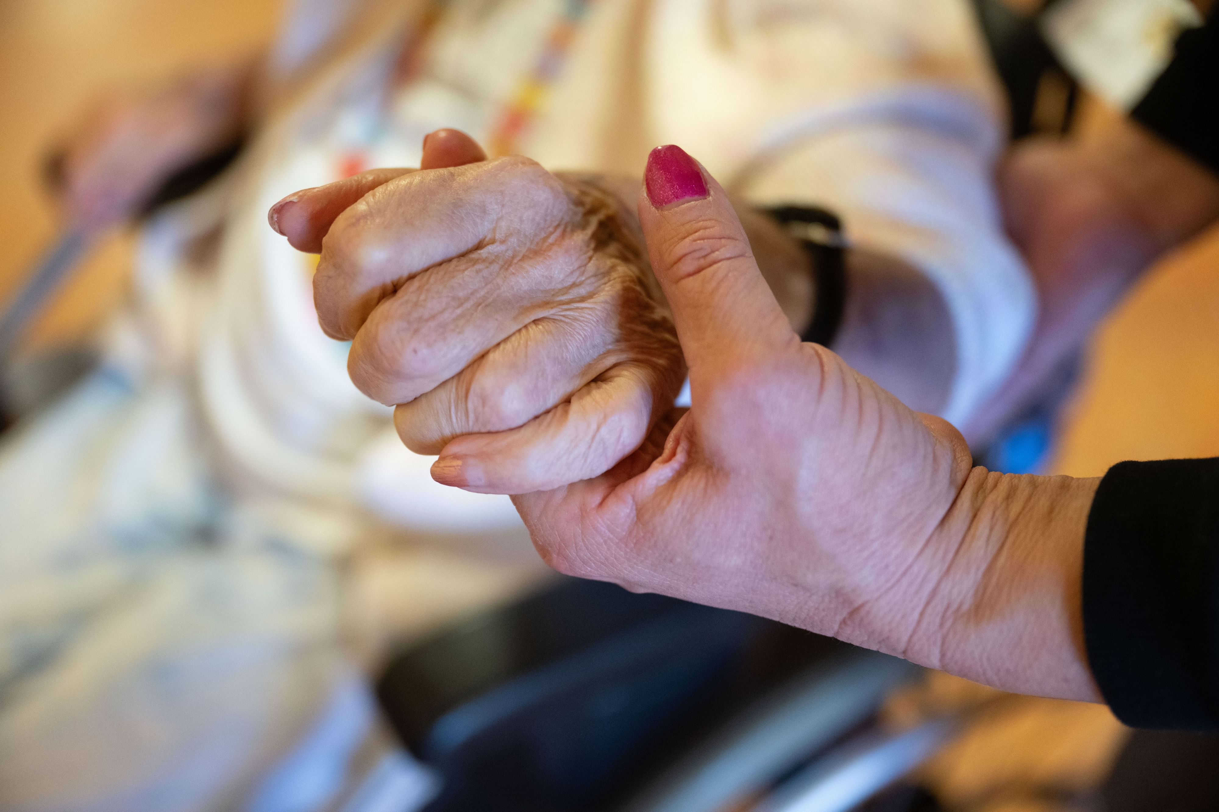 Eine Physiotherapeutin hält die Hand und den Ellenbogen einer Pflegebedürftigen. (Symbolbild)