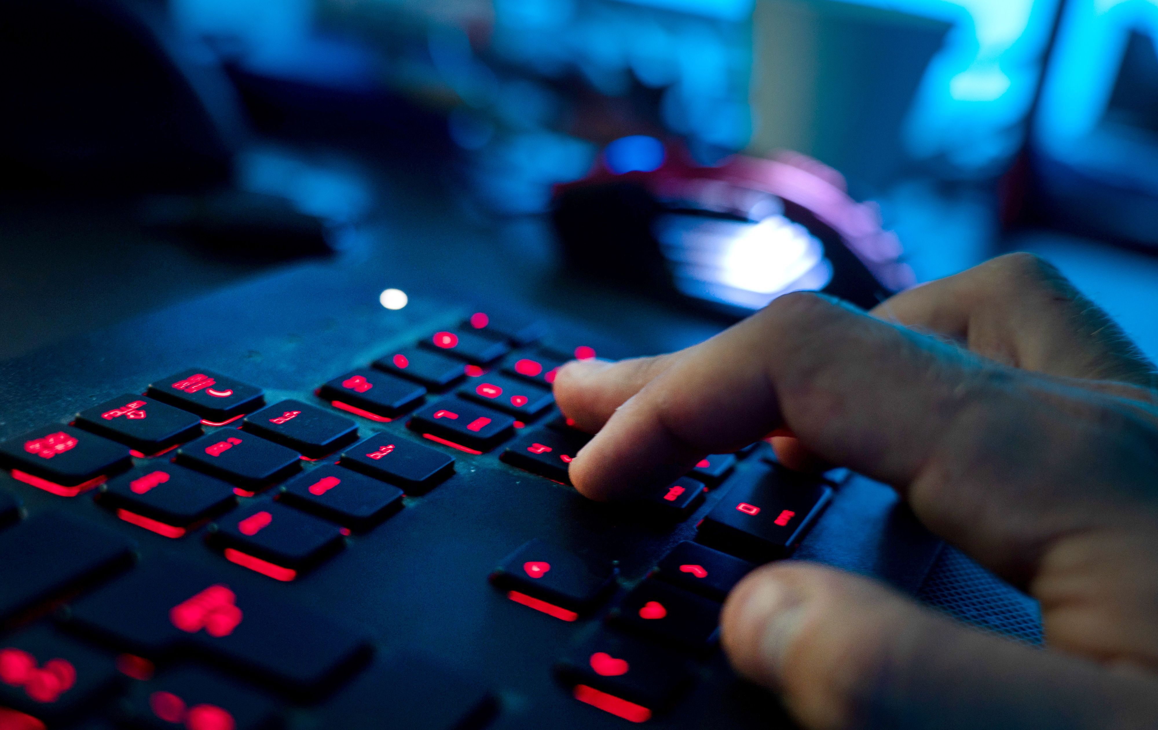 Ein Mann sitzt am Rechner und tippt auf einer Tastatur. NRW will die kommunale IT-Infrastruktur einheitlicher gestalten.