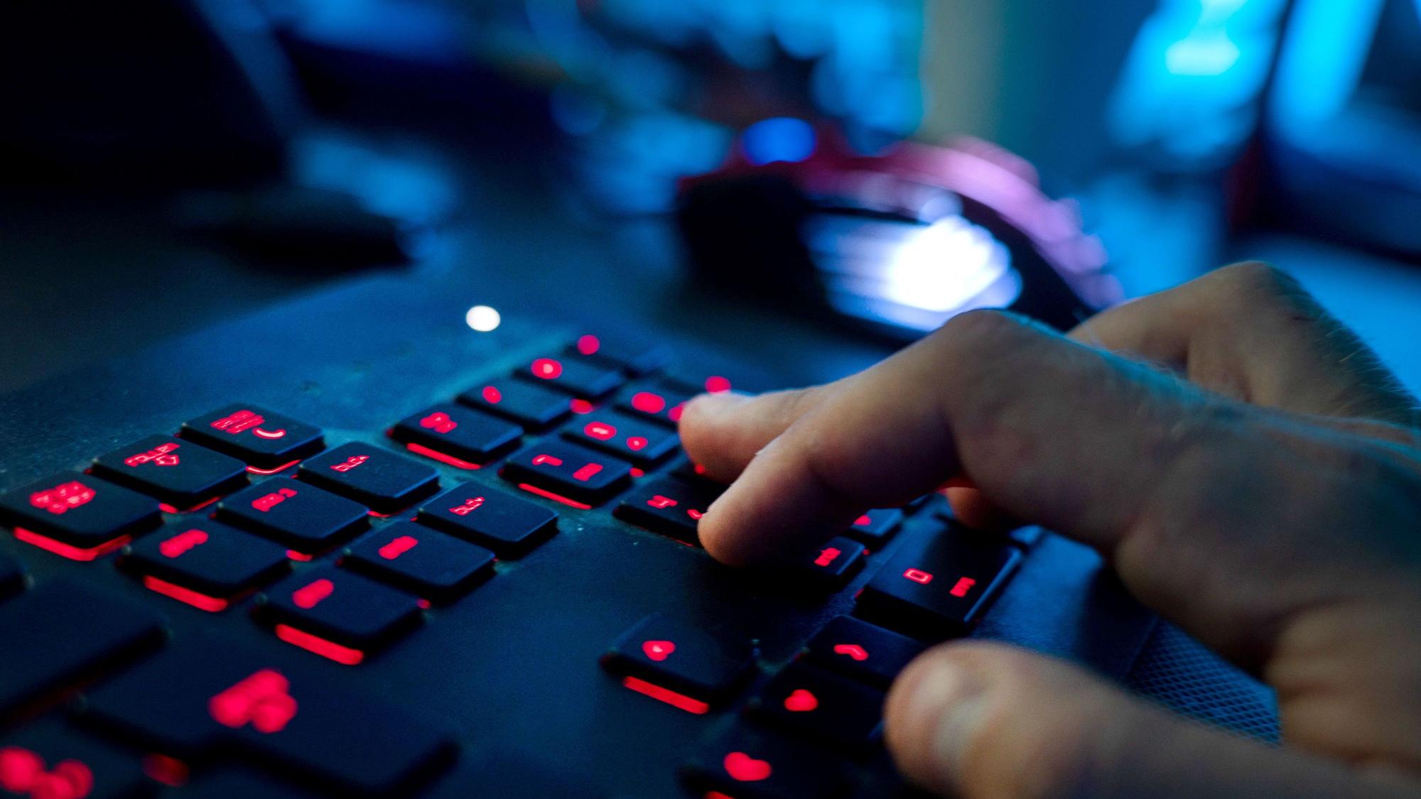 Ein Mann sitzt am Rechner und tippt auf einer Tastatur. NRW will die kommunale IT-Infrastruktur einheitlicher gestalten.