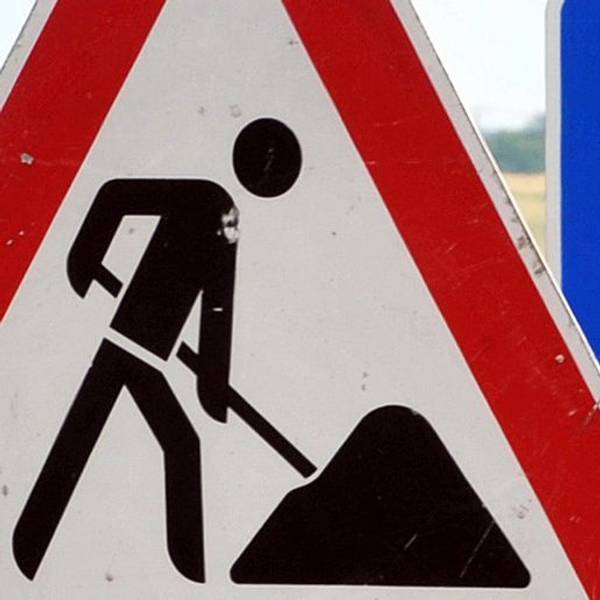 in Baustellenschild ist vor einem Autobahnschild platziert.