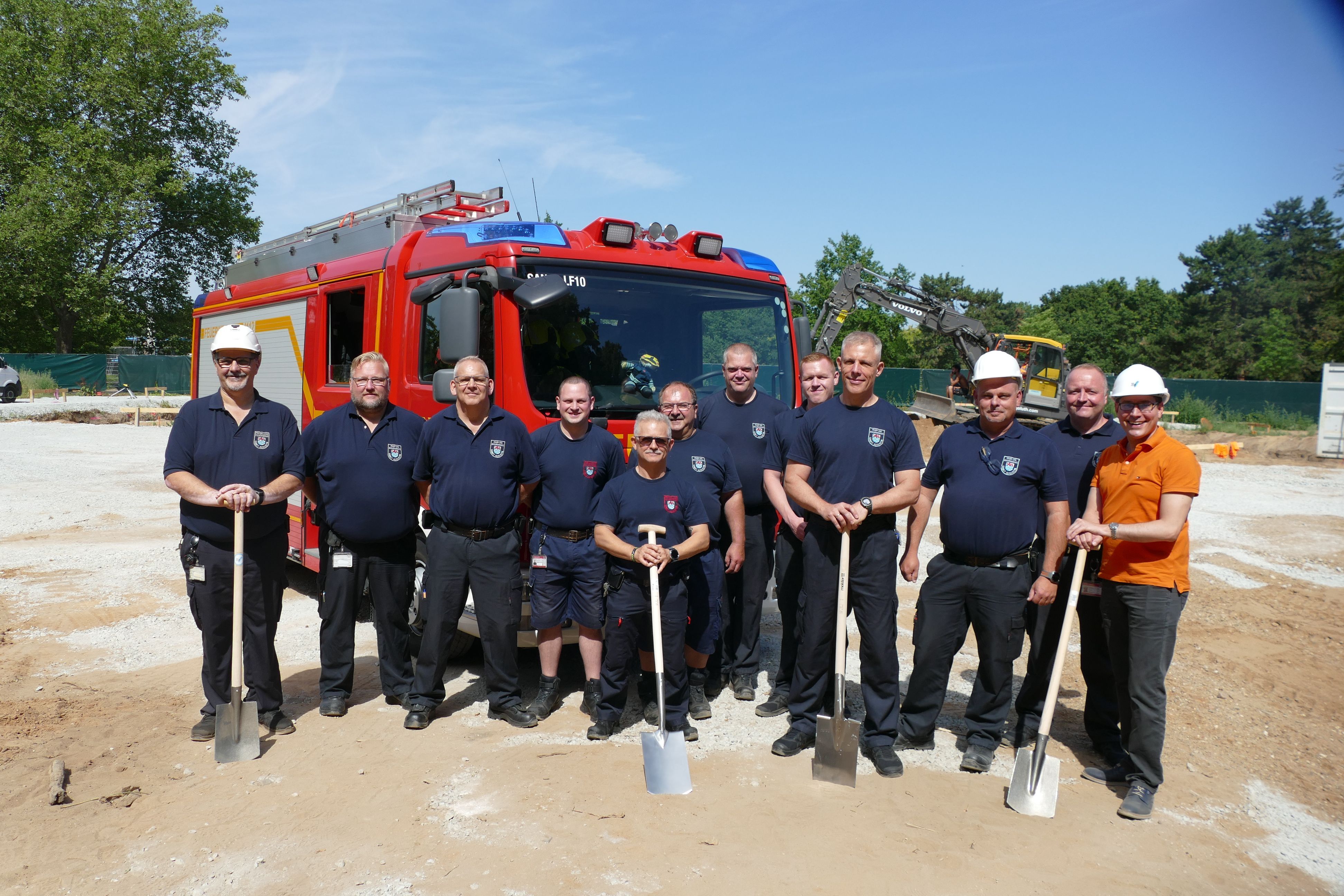 Die Mitarbeiter der Feuerwehrtechnischen Zentrale und Bürgermeister Max Leitterstorf (in orange) beim Spatenstich.