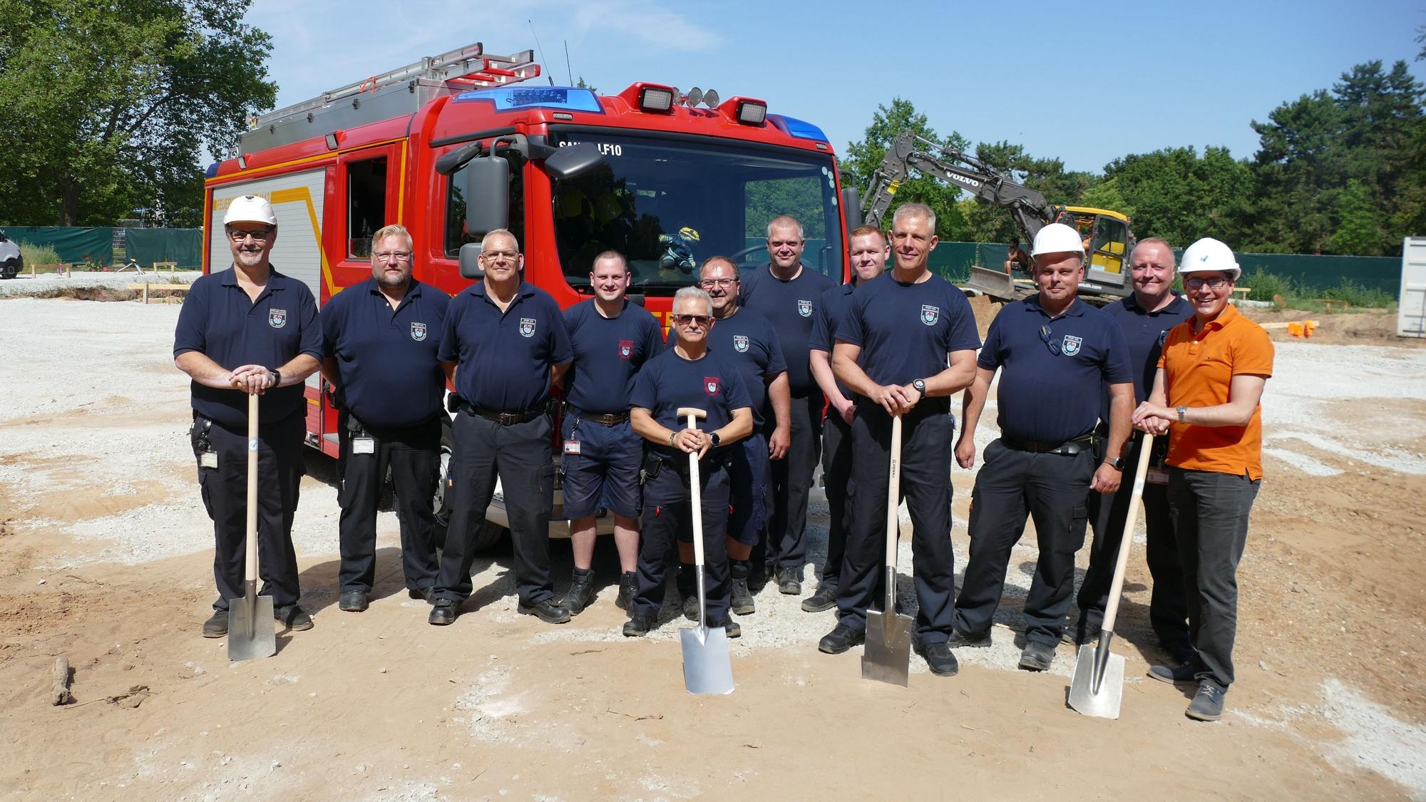 Die Mitarbeiter der Feuerwehrtechnischen Zentrale und Bürgermeister Max Leitterstorf (in orange) beim Spatenstich.