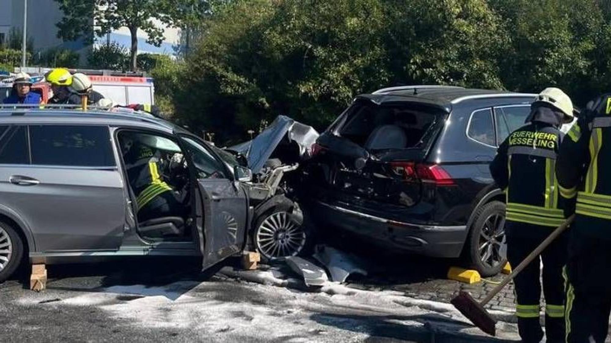 Feuerwehrleute an der Unfallstelle an den zerstörten Autos.