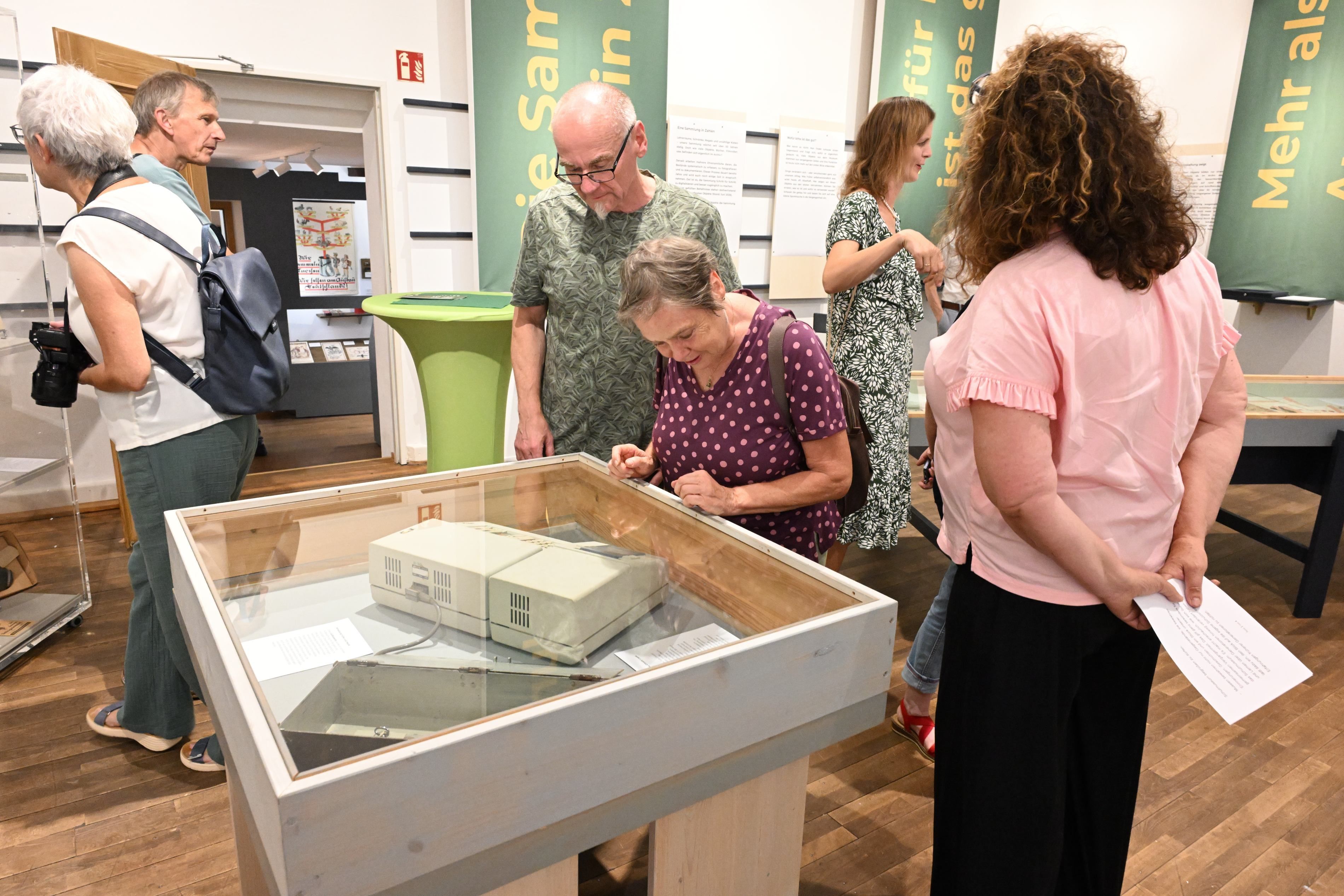 Gäste laufen durchs Museum und betrachten Objekte.