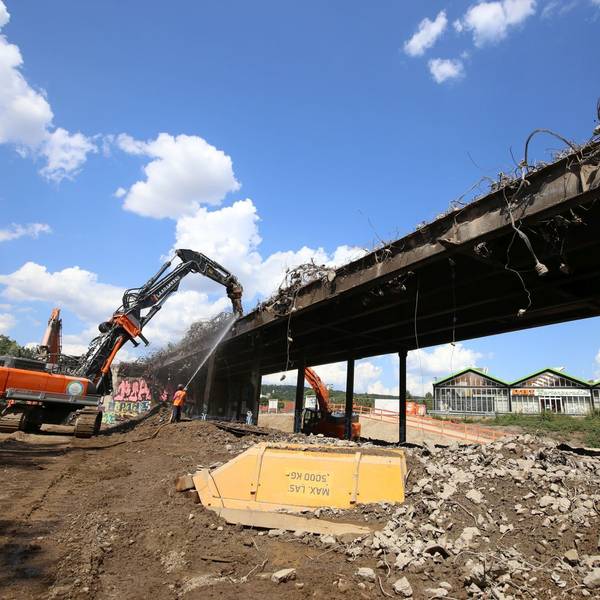 Ein Großbagger beim Abriss einer Brücke.