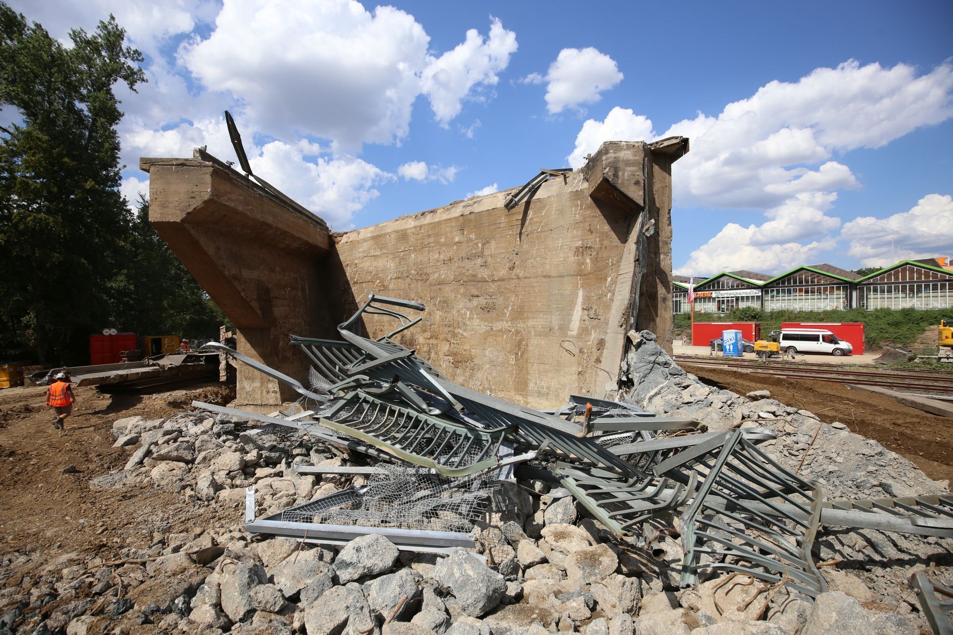 Ein Betonturm, davor verbogene Metallgeländer.