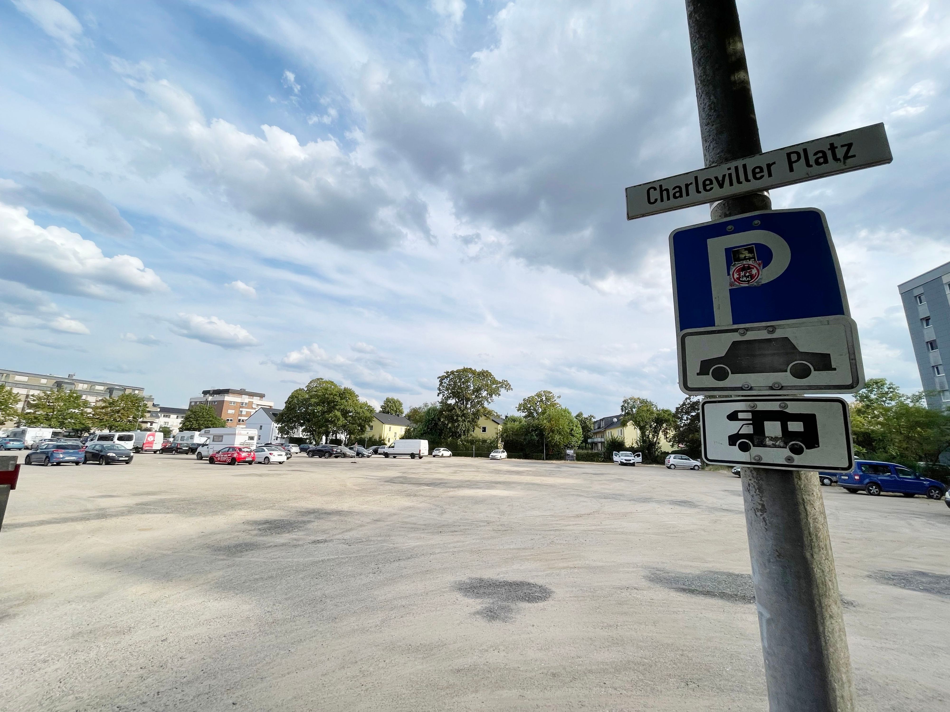 Am Rande des Geländes hängen Schilder mit Auto- und Wohnmobilpiktogrammen.