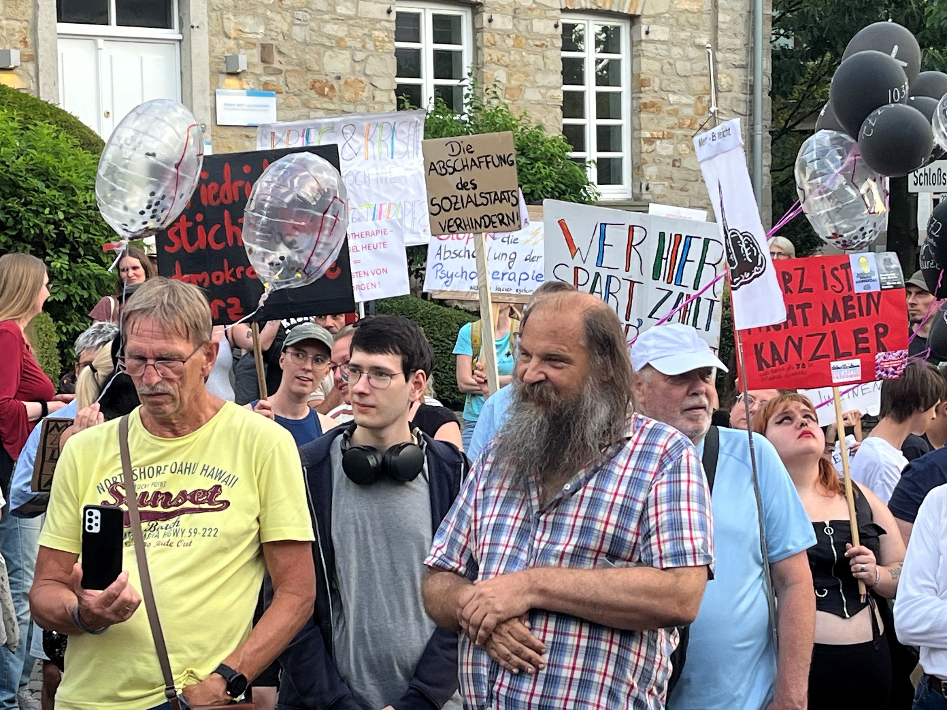 Demonstranten halten Plakate hoch.