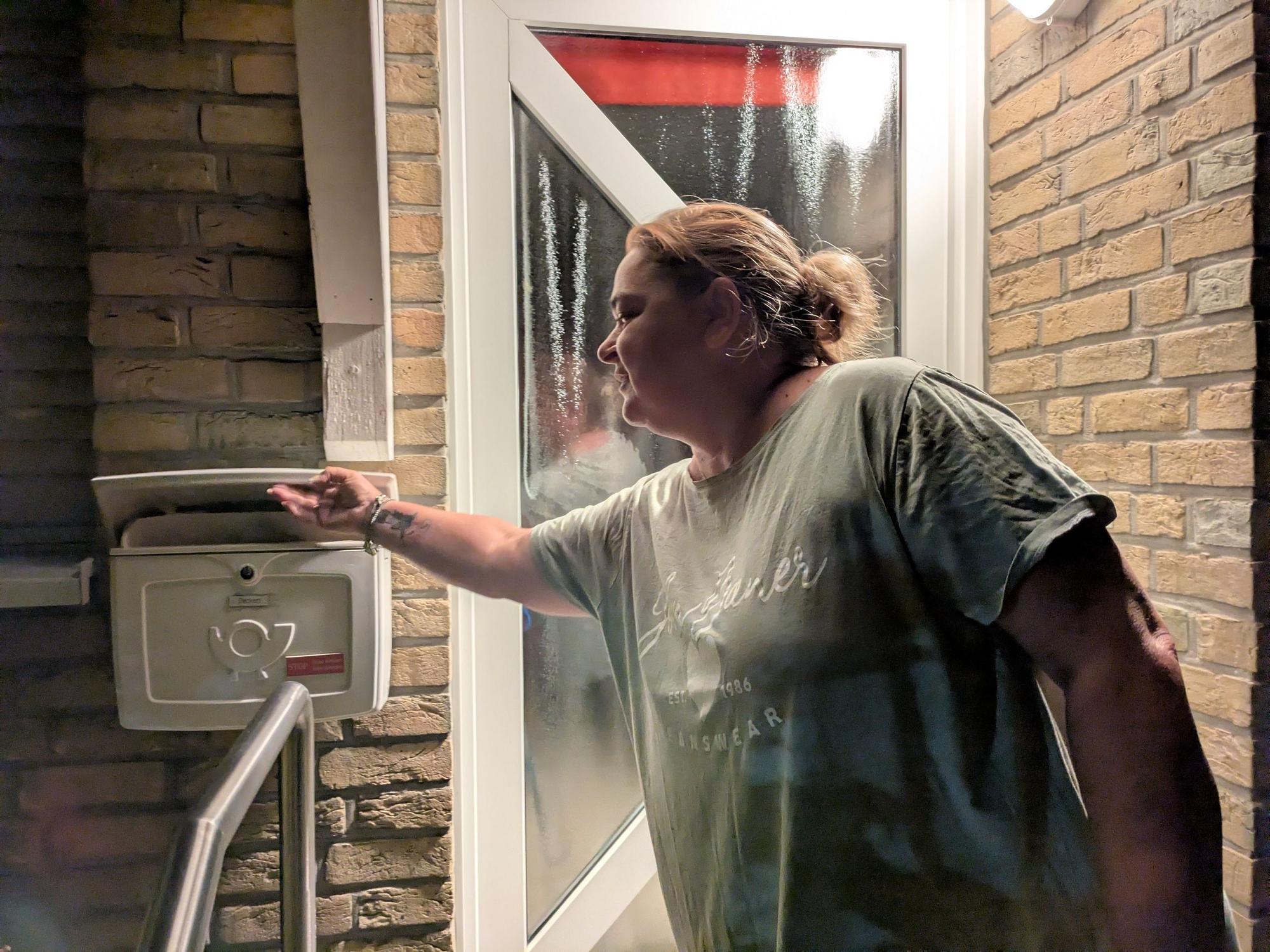 Janine Rübsaat steckt eine Zeitung in einen Briefkasten.