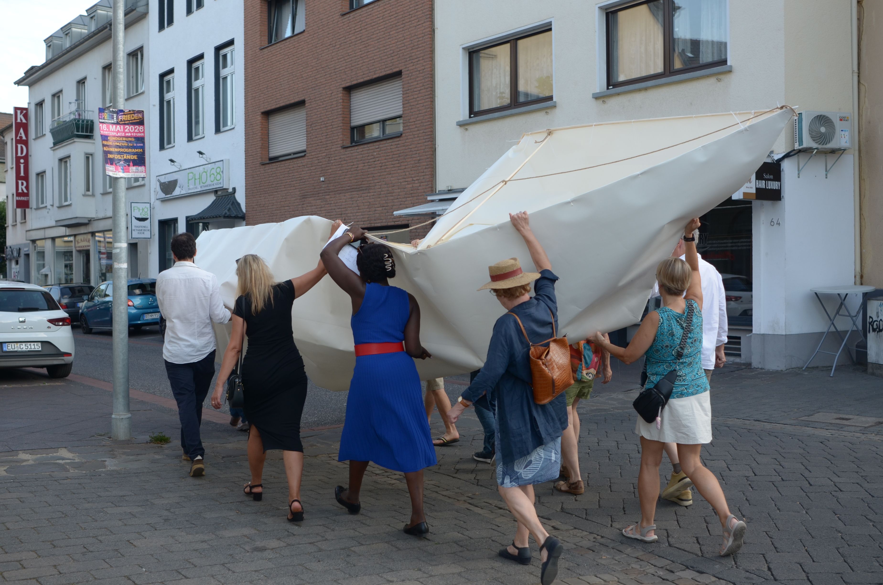 Die Frauen und Männer tragen das Boot durch eine Straße.
