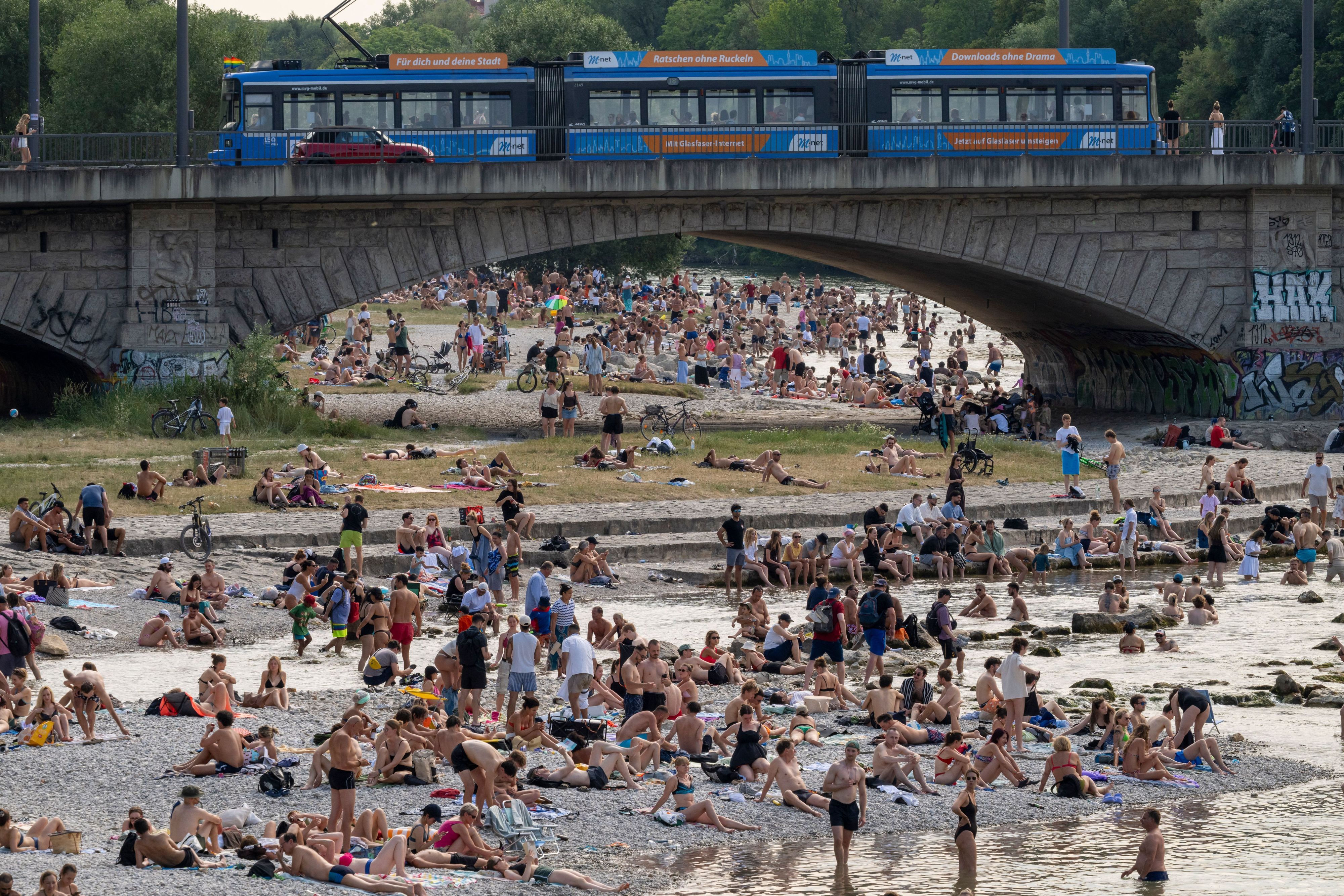 Badende genießen die Abkühlung im Wasser der Isar im Herzen der bayerischen Landeshauptstadt.