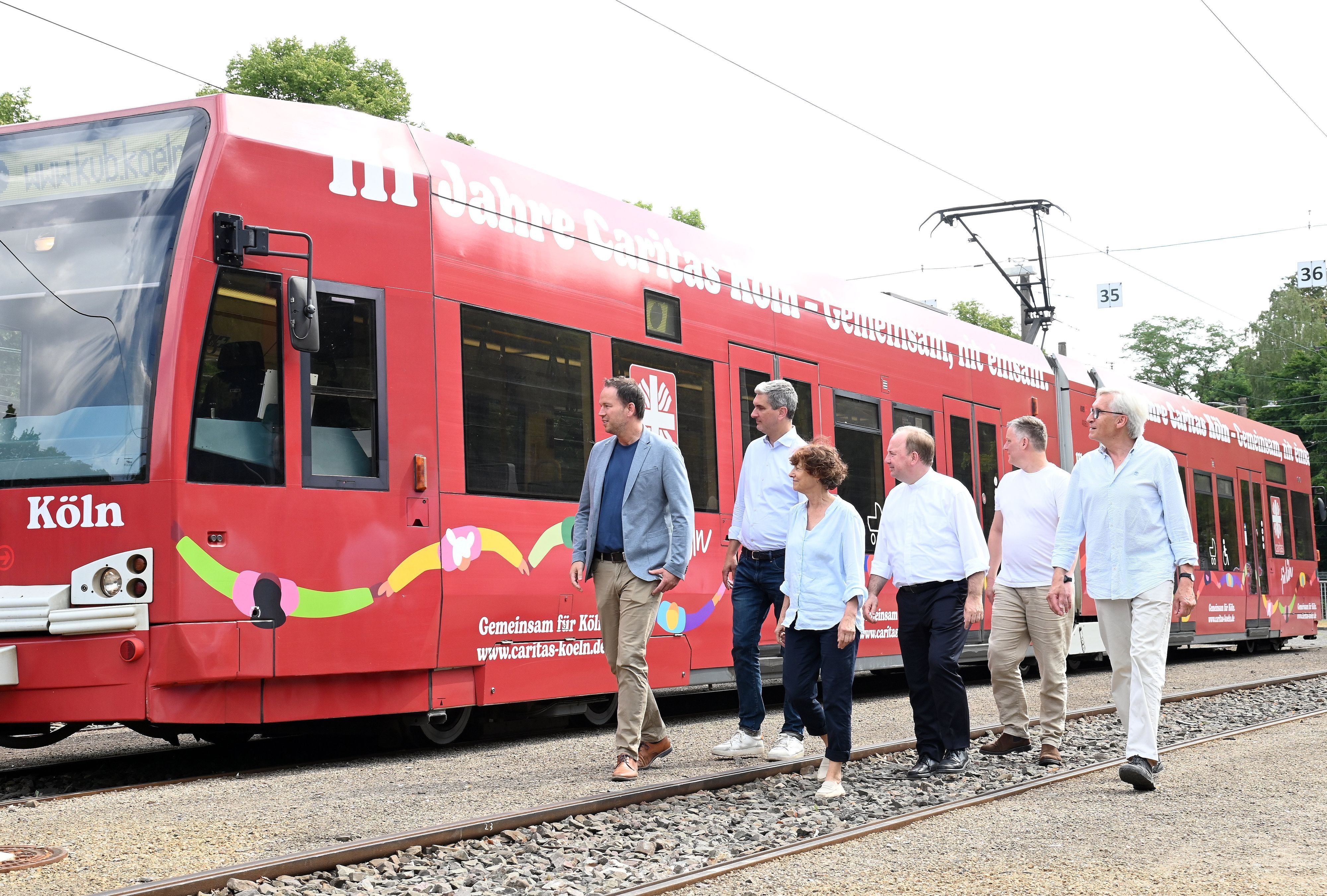 16.07.2026 Köln. Eine KVB Stadtbahn zum 111-jährigen Jubiläum der Caritas Köln. V.Li.: Marcel Winter, Markus Peters, Katharina Oxenius, Monsignore Robert Kleine, Nils Freund, Werner Lenz. Foto: Alexander Schwaiger