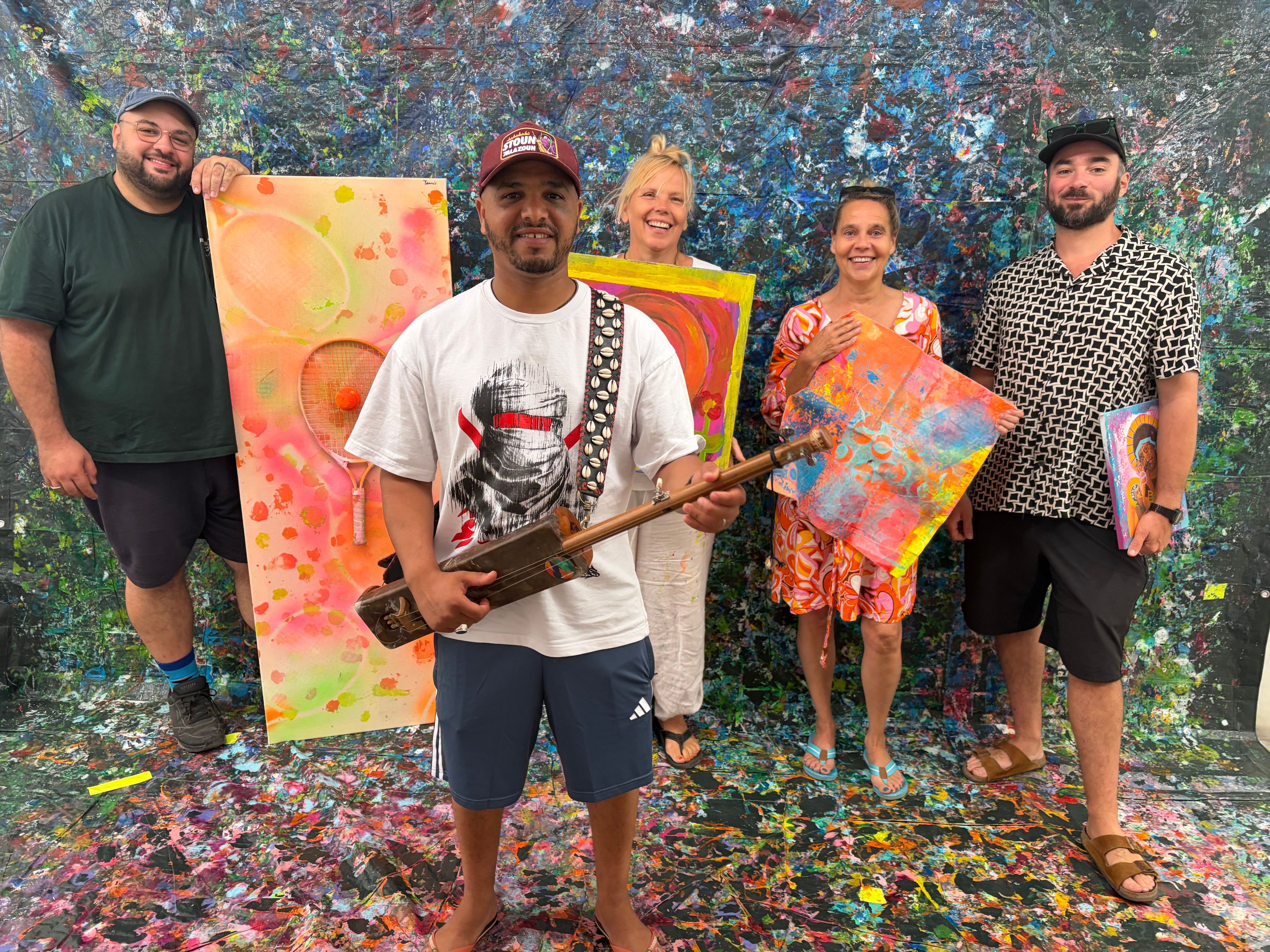 Das Künstlerkollektiv Planet Art auf und vor den mit Farbe betanzten Leinwänden.