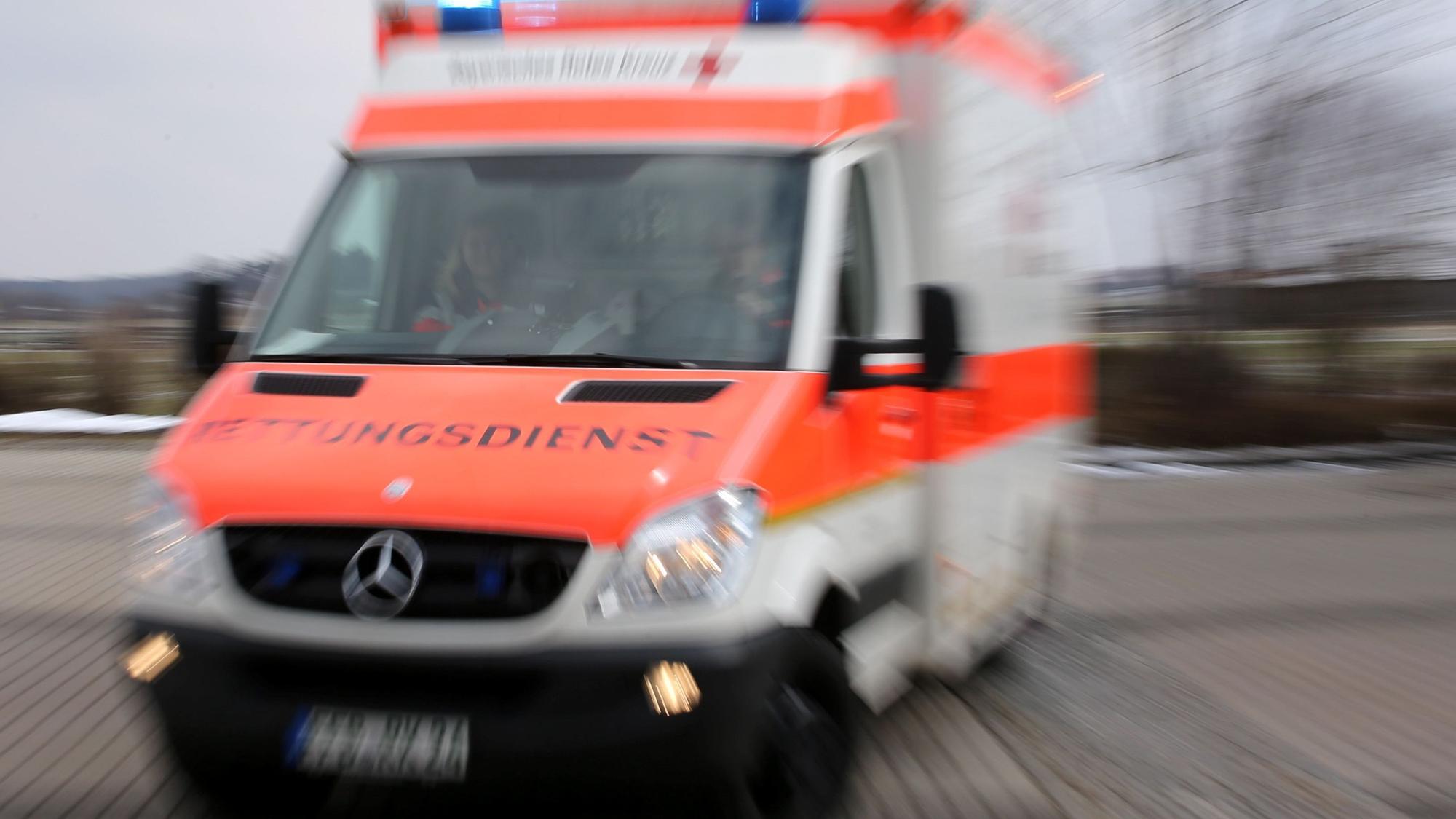 Ein Rettungswagen fährt auf einen Parkplatz.
