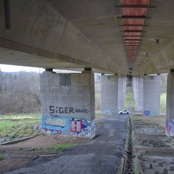 Zu sehen ist eine Autobahnbrücke von unten.