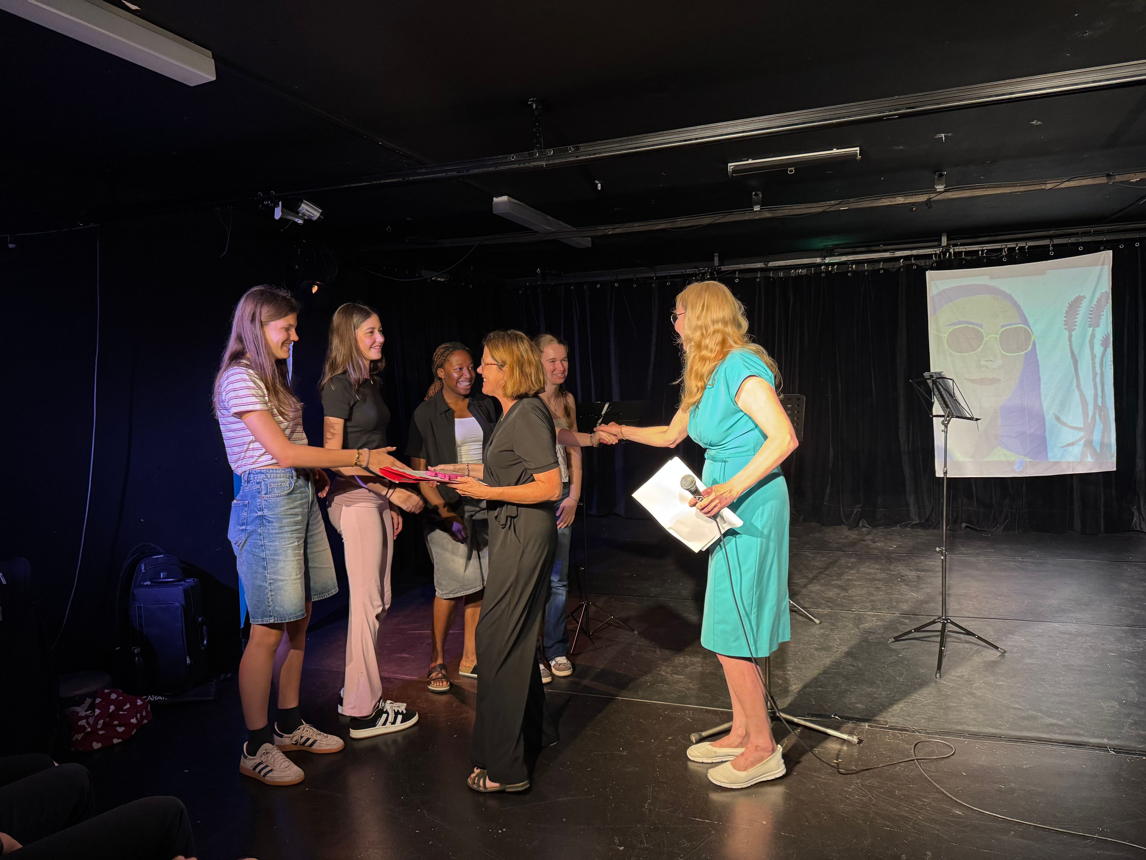 Anke Holgersson und Mirjam Wandhoff verleihen einen der Theaterpreise an das Schauspielensemble der Musik- und Kunstschule Leverkusen.
