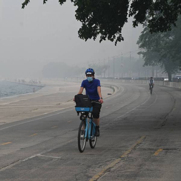 Eine Radfahrerin trägt in Chicago eine Maske, um sich vor der schlechten Luft zu schützen.
