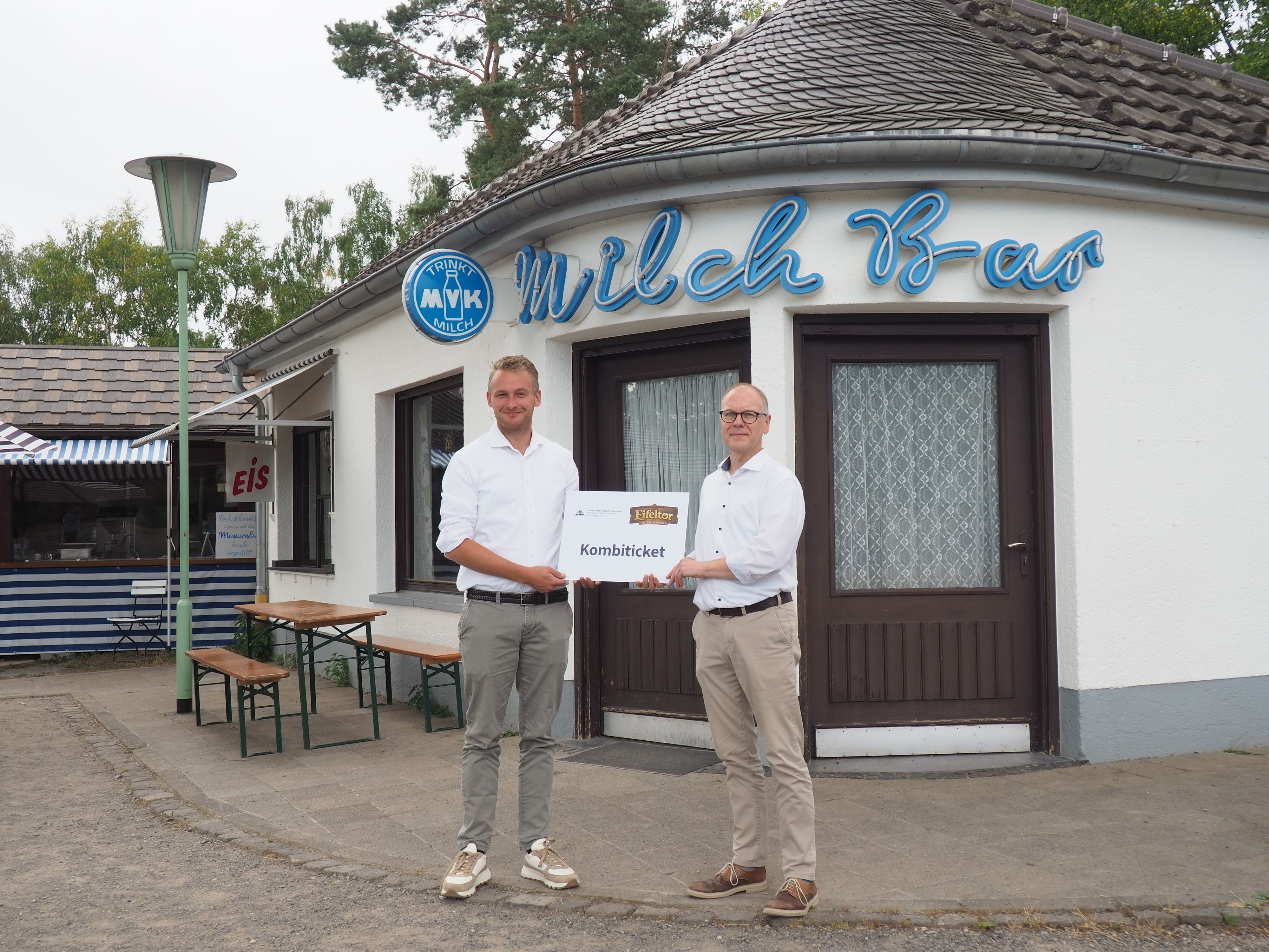 Roland Barth (l.) und Dr. Carsten Vorwig stehen im Museum vor der Milchbar und halten gemeinsam ein übergroßes Kombiticket.