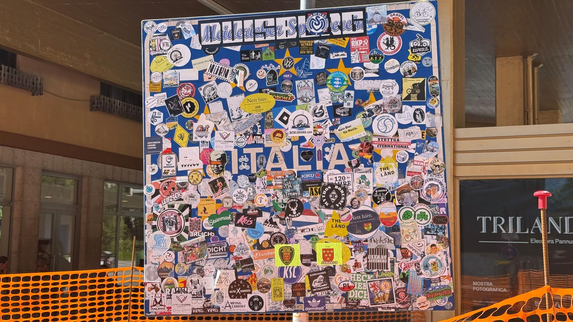 Ein bunt beklebtes Hinweisschild, dass man jetzt in Italien angekommen ist.