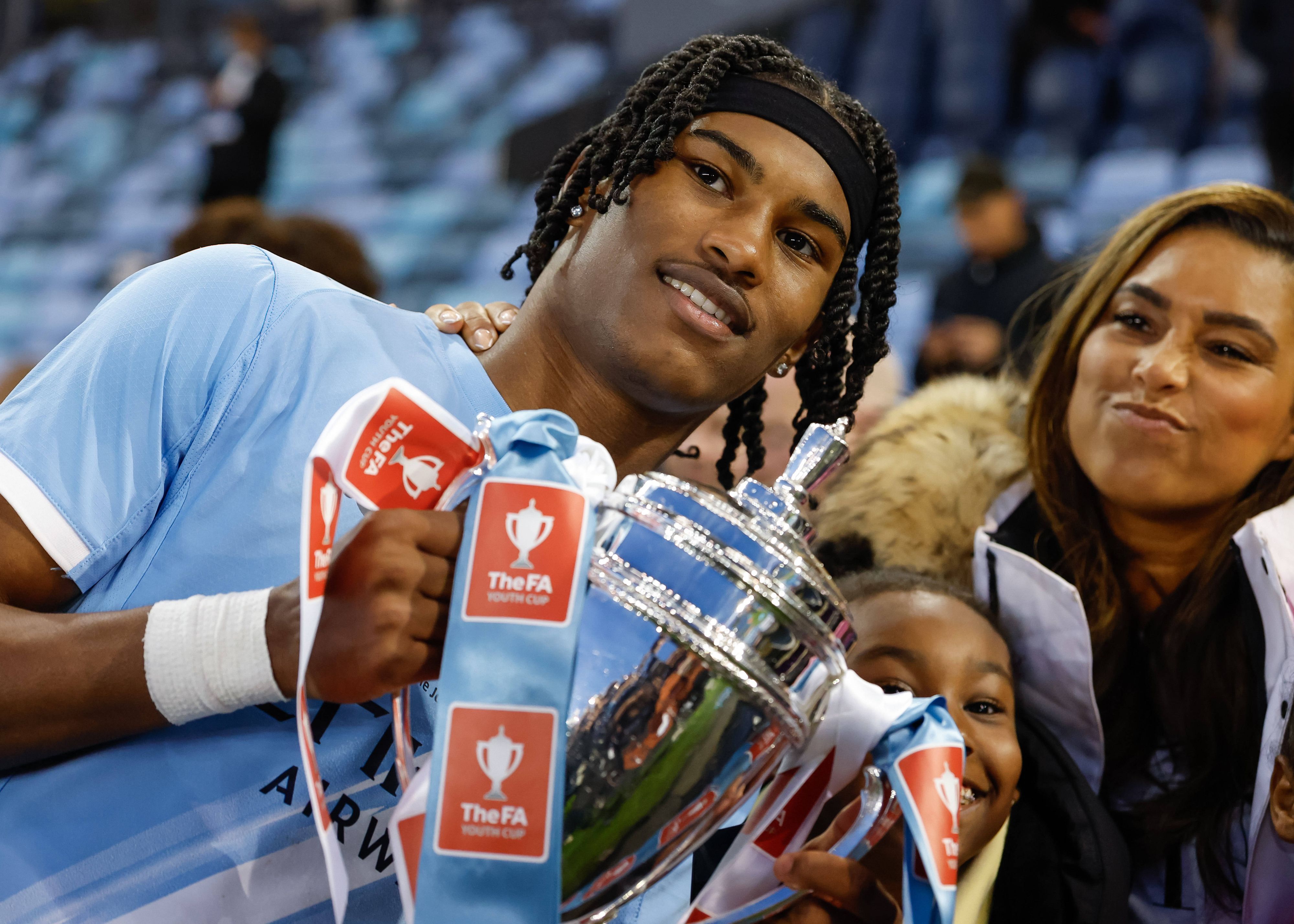 Reigan Heskey feiert mit einem Pokal in den Händen.