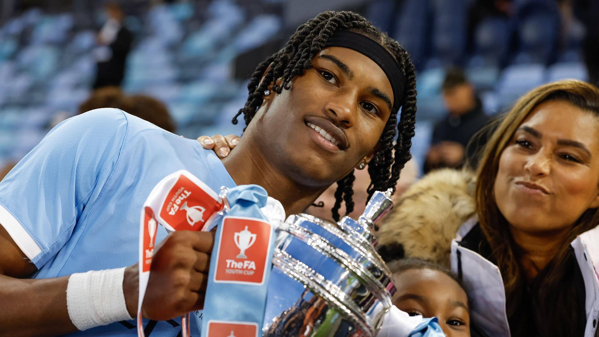 Reigan Heskey feiert mit einem Pokal in den Händen.
