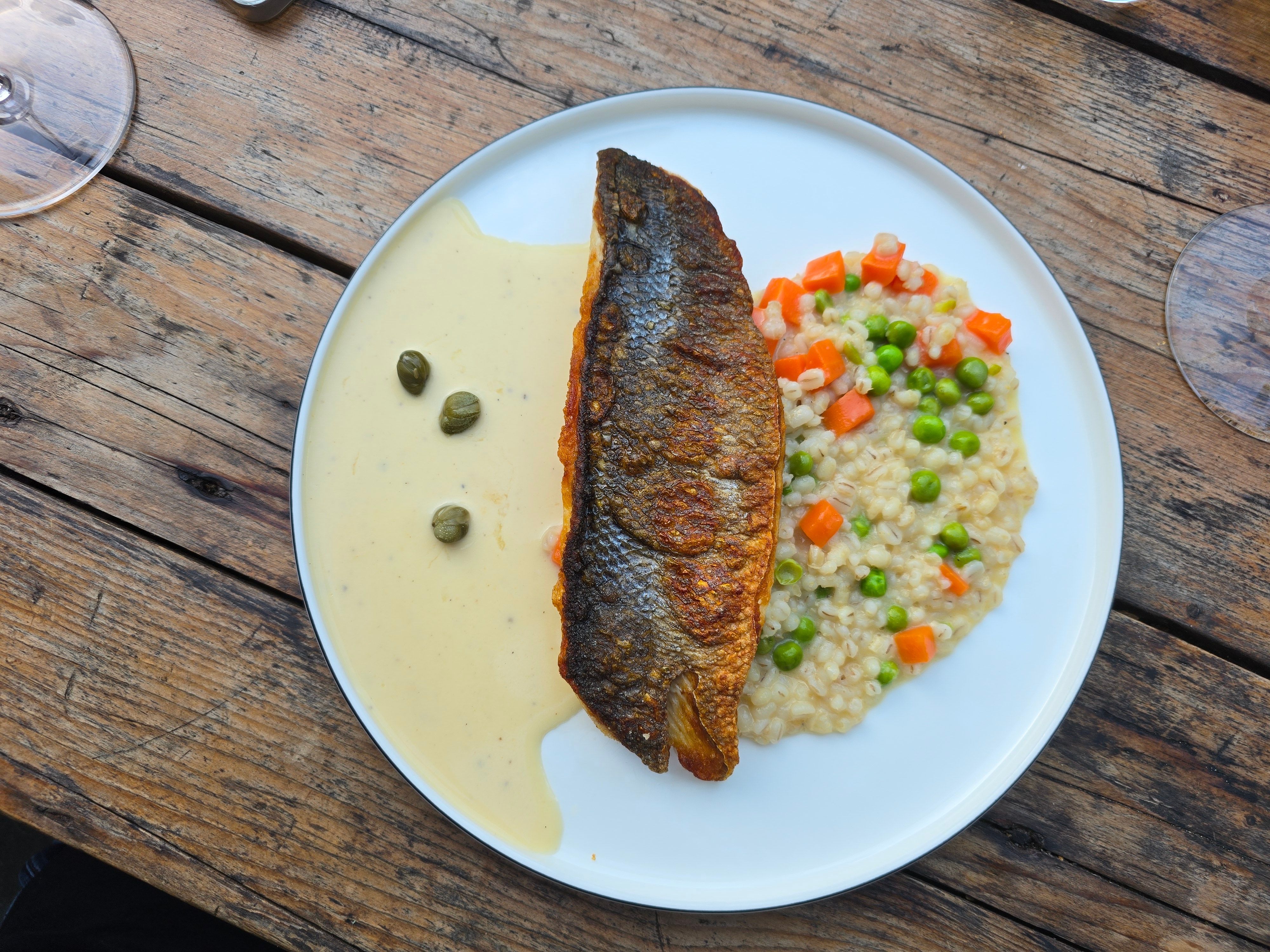 Wolfsbarsch mit Graupenrisotto, Erbsengemüse, Kapernbuttersauce