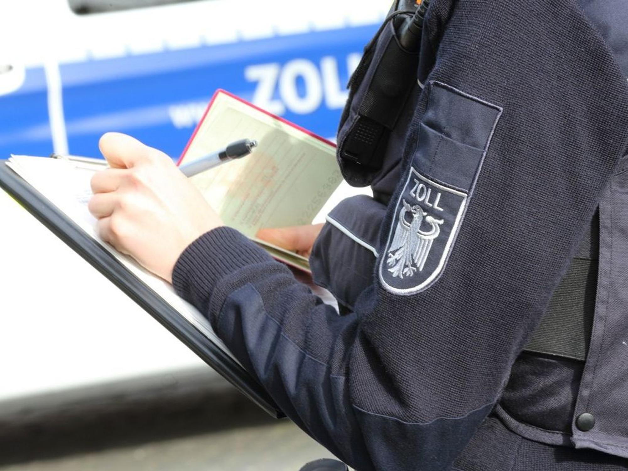 Ein Mitarbeiter des Zolls notiert sich etwas.