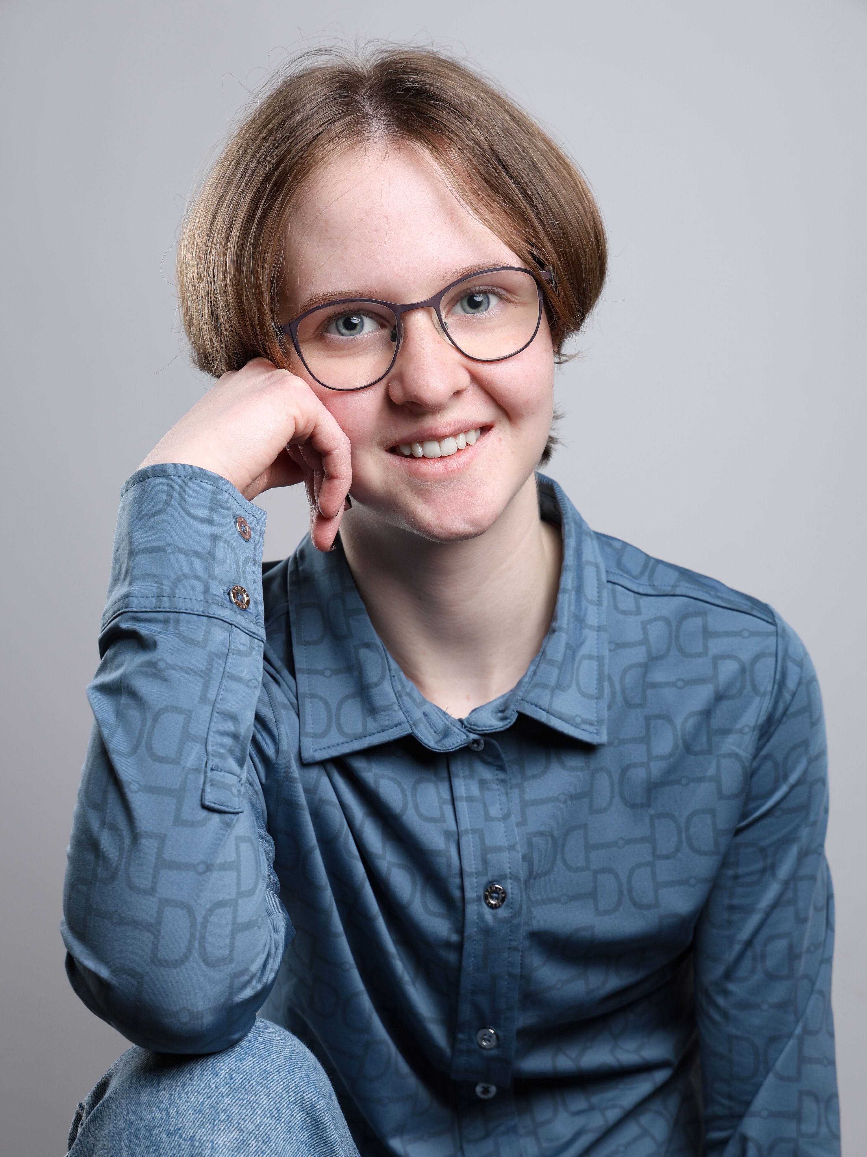 Maribelle Aßmus posiert für ein Portrait, stützt den Kopf auf eine Hand.
