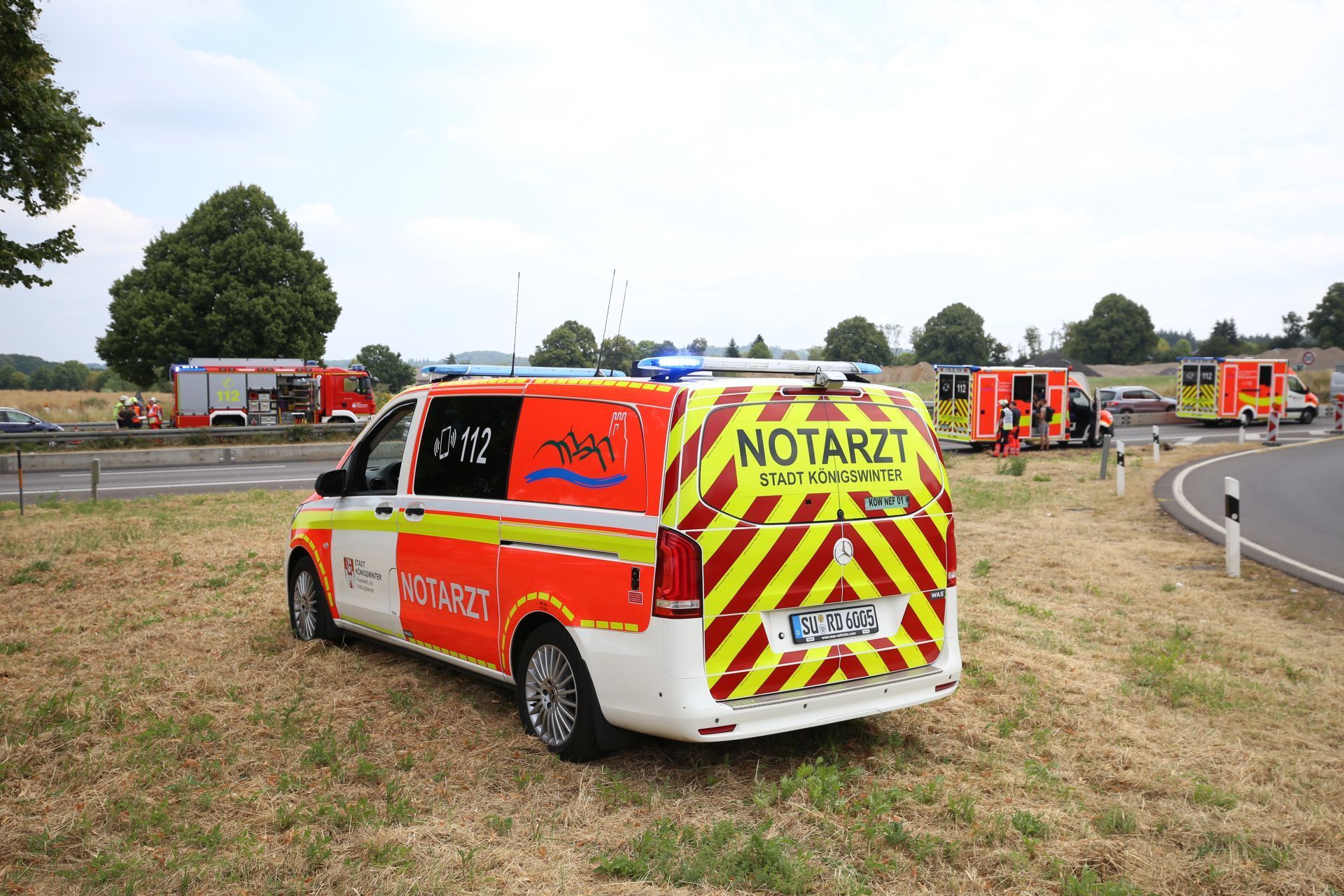 Rettungswagen, Feuerwehr und Notarztfahrzeuge an einer Autobahnzufahrt.