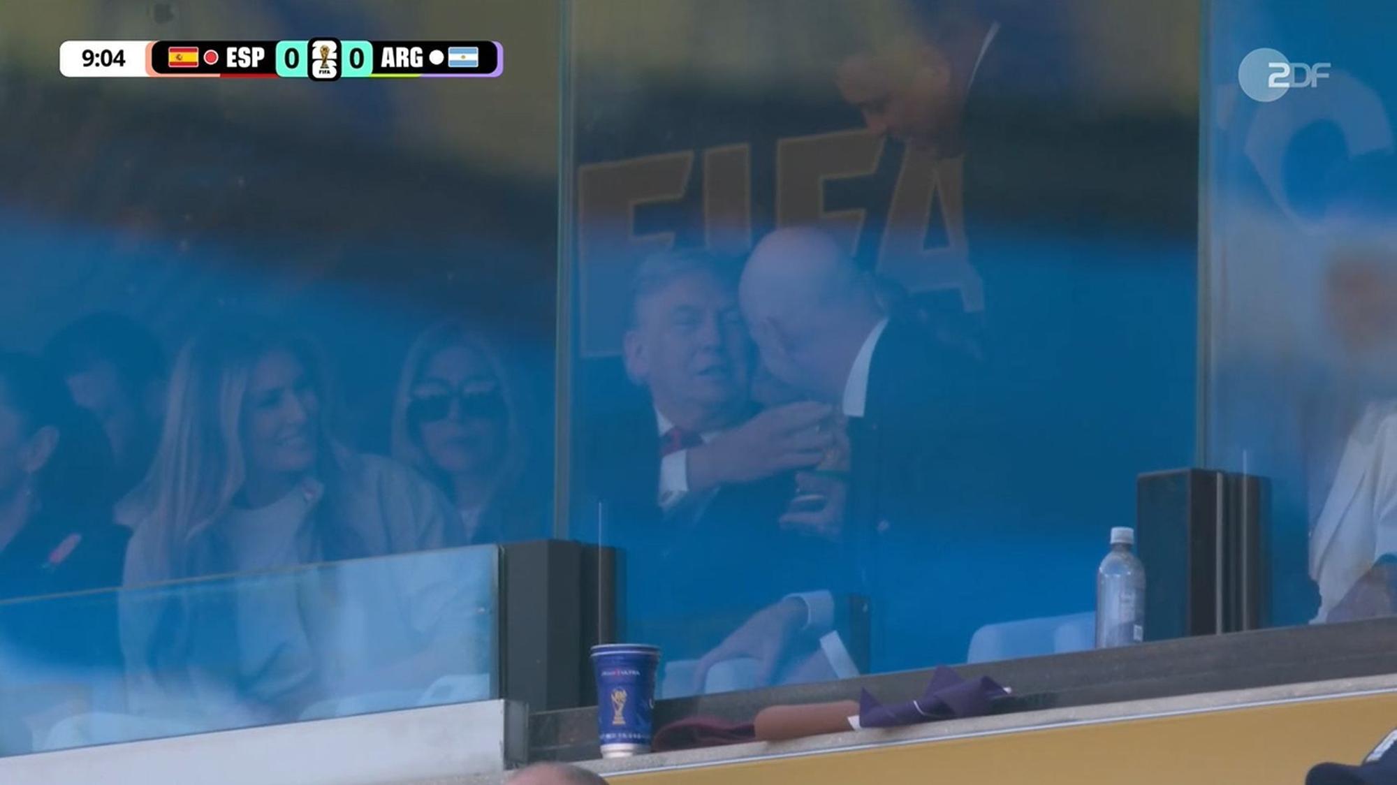 Donald Trump fasst den WM-Pokal an.